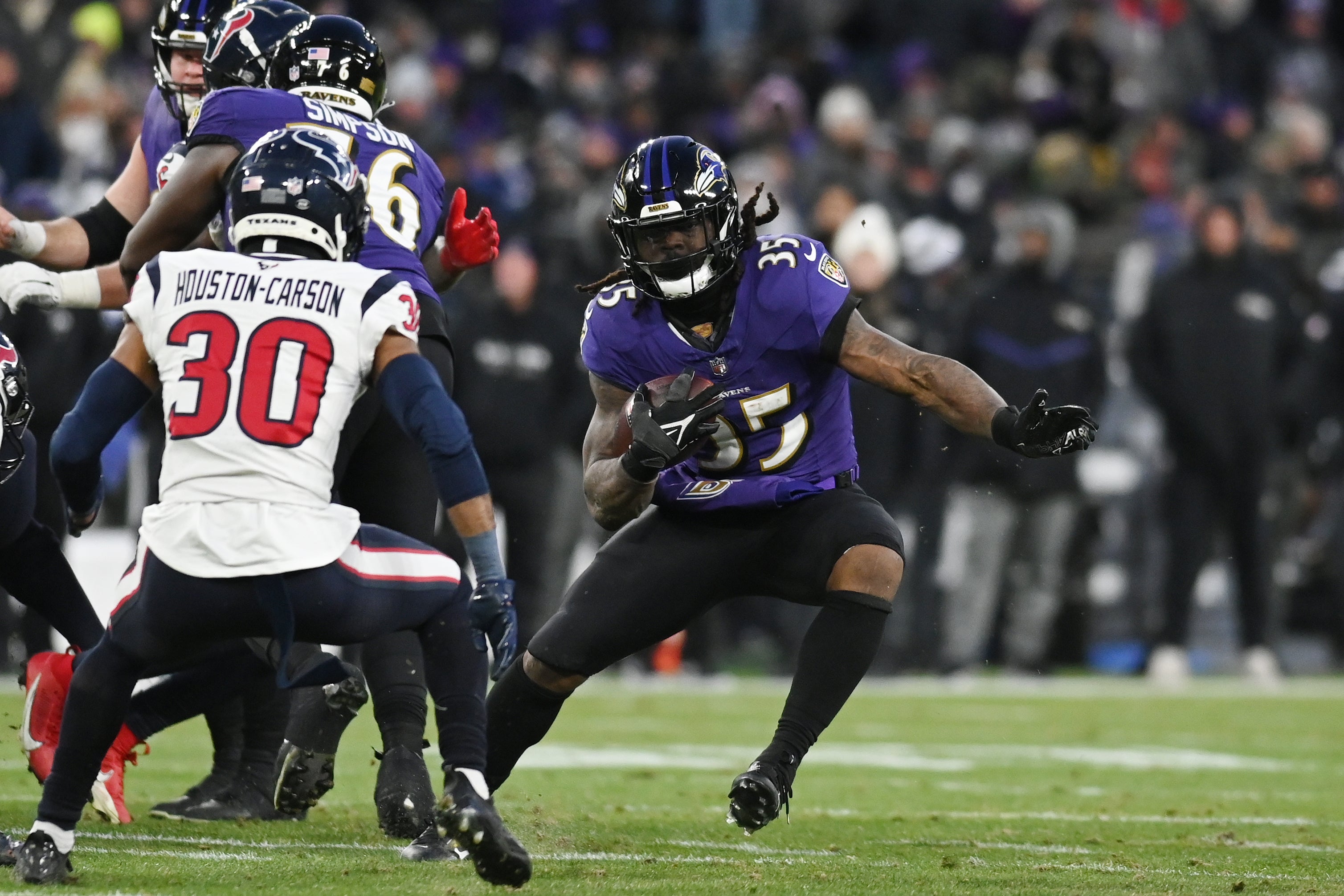 Jan 20, 2024; Baltimore, MD, USA; Baltimore Ravens running back Gus Edwards (35) runs the ball against Houston Texans safety DeAndre Houston-Carson (30) during the second quarter in a 2024 AFC divisional round game at M&T Bank Stadium.