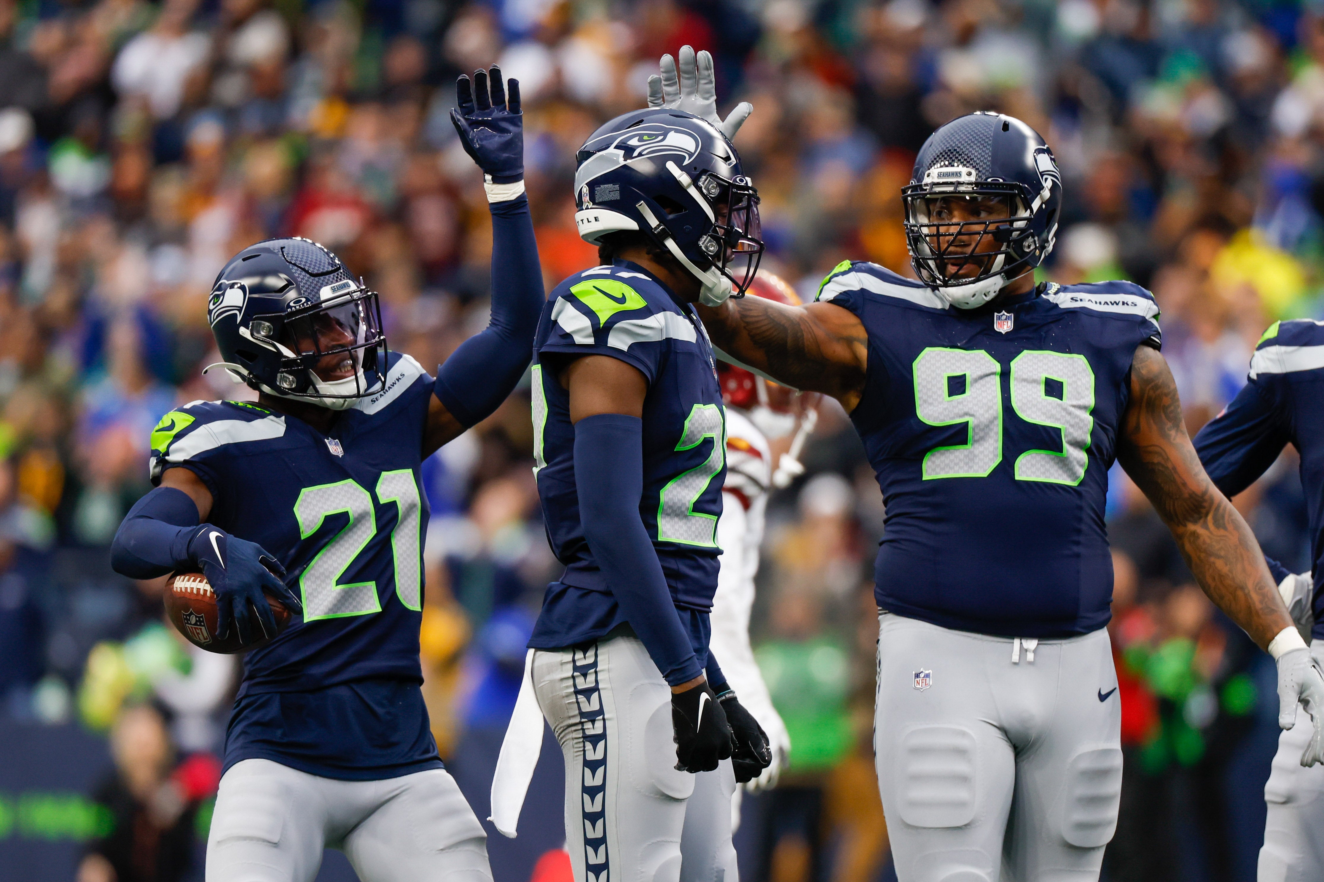 Nov 12, 2023; Seattle, Washington, USA; Seattle Seahawks cornerback Devon Witherspoon (21), cornerback Riq Woolen (27) and defensive end Leonard Williams (99) celebrate following a play against the Washington Commanders during the second quarter at Lumen Field.
