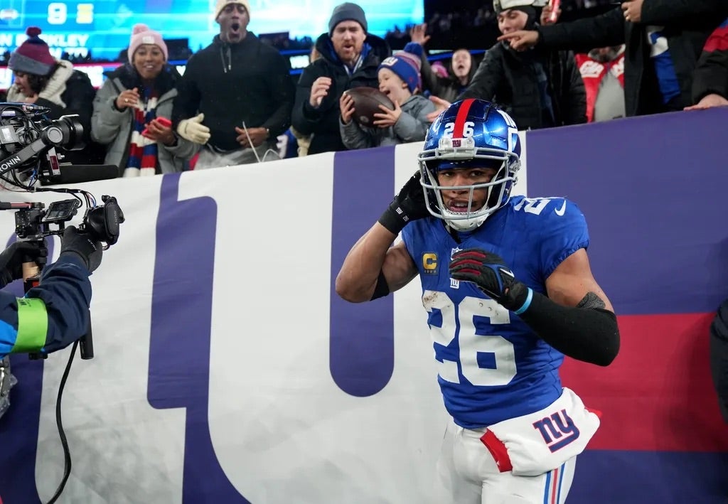 New York Giants running back Saquon Barkley (26) is shown after scoring a touchdown and giving the ball to Harrison Isaacs.