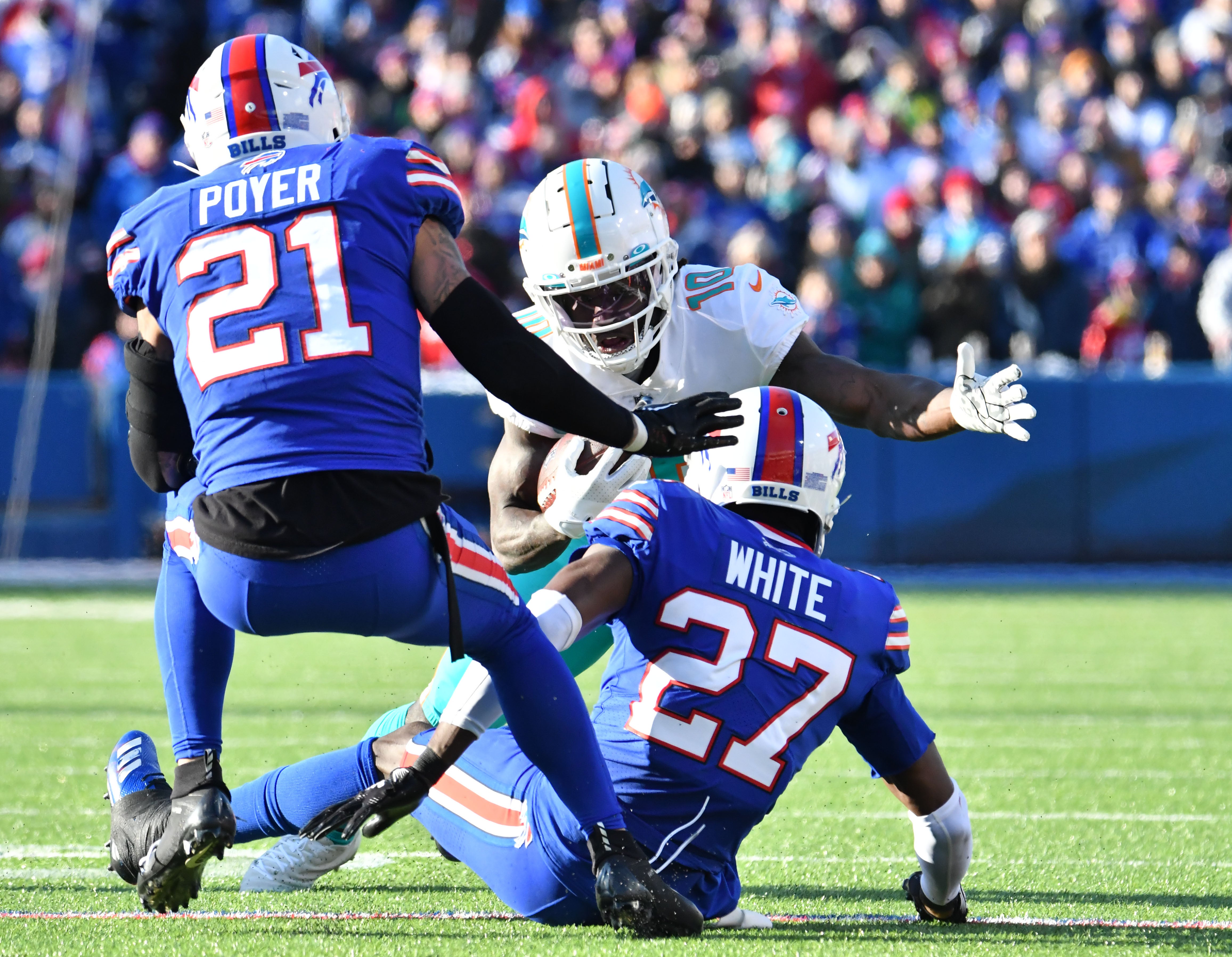 Jan 15, 2023; Orchard Park, NY, USA; Miami Dolphins wide receiver Tyreek Hill (10) tries to get away from Buffalo Bills cornerback Tre'Davious White (27) and safety Jordan Poyer (21) during the first half in a NFL wild card game at Highmark Stadium.
