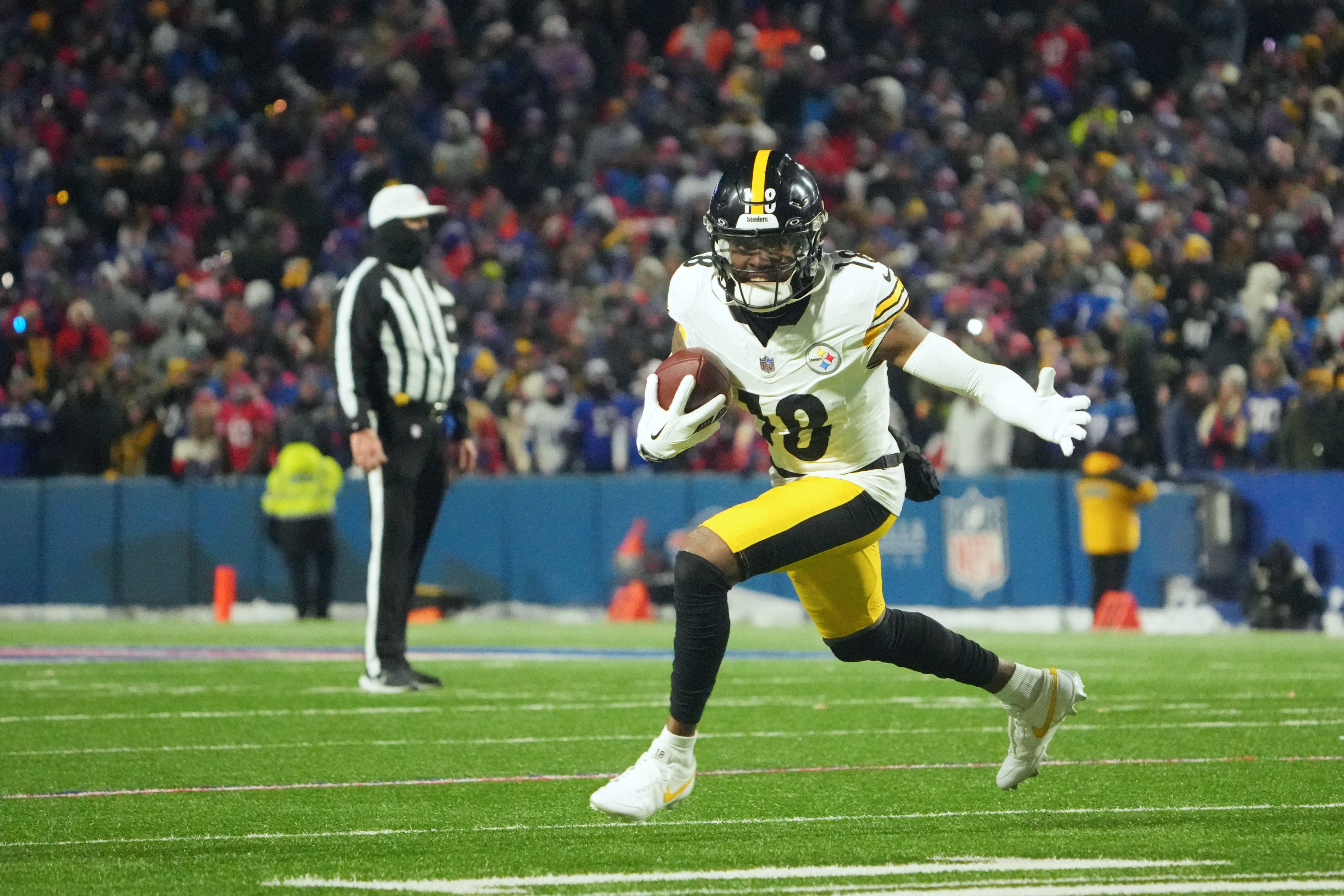 Jan 15, 2024; Orchard Park, New York, USA; Pittsburgh Steelers wide receiver Diontae Johnson (18) runs the ball in the second half against the Buffalo Bills in a 2024 AFC wild card game at Highmark Stadium.