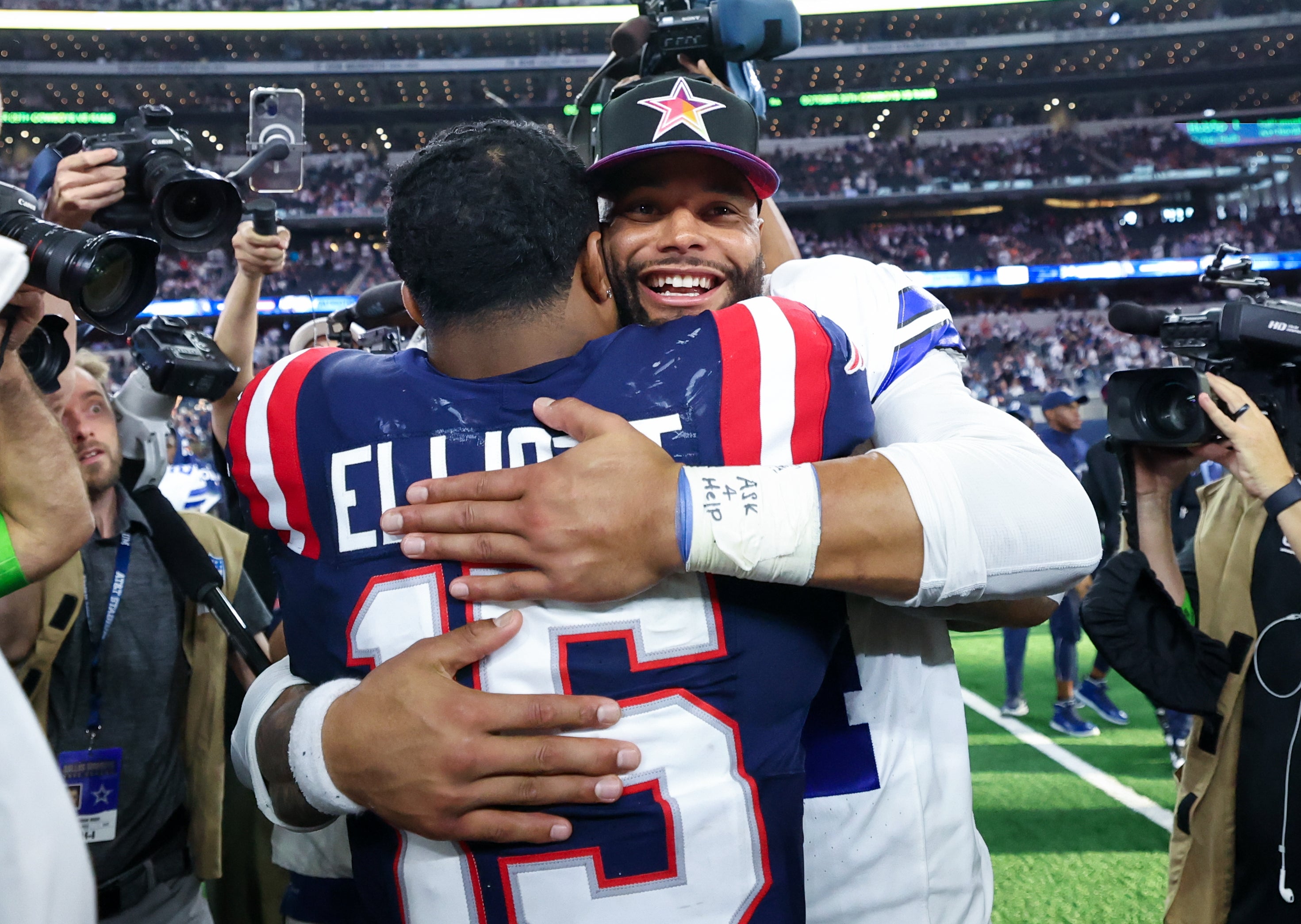 Dallas Cowboys quarterback Dak Prescott (4) hugs New England Patriots running back Ezekiel Elliott (15) after the game at AT&T Stadium.
