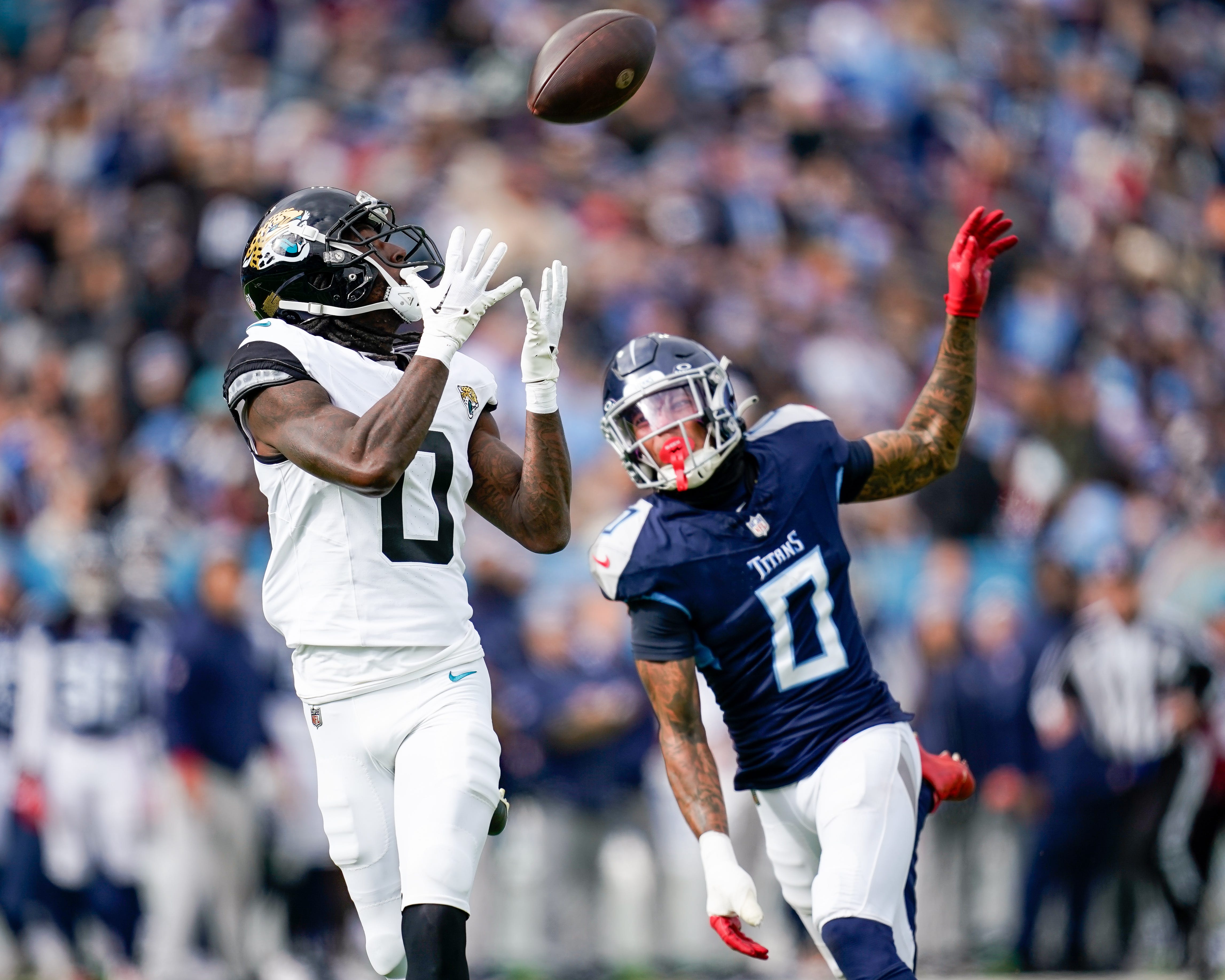 Jacksonville Jaguars wide receiver Calvin Ridley (0) receives a pass to bring in a touchdown past Tennessee Titans cornerback Sean Murphy-Bunting (0) during the second quarter at Nissan Stadium in Nashville, Tenn., Sunday, Jan. 7, 2024.