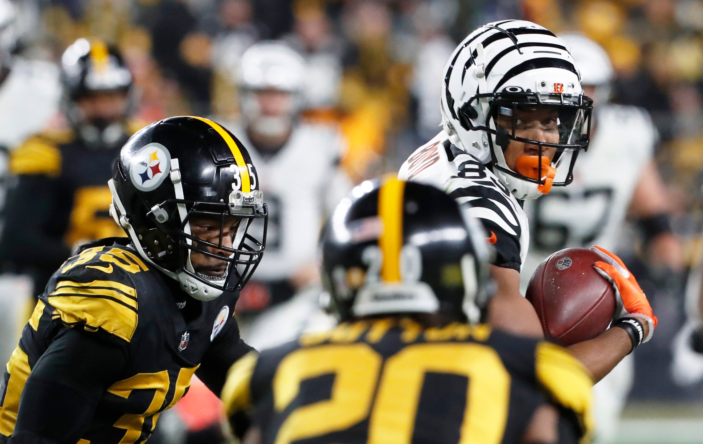 Nov 20, 2022; Pittsburgh, Pennsylvania, USA; Cincinnati Bengals wide receiver Tyler Boyd (83) runs after a catch as Pittsburgh Steelers cornerbacks Arthur Maulet (35) and Cameron Sutton (20) defend during the fourth quarter at Acrisure Stadium. Mandatory Credit: Charles LeClaire-USA TODAY Sports
