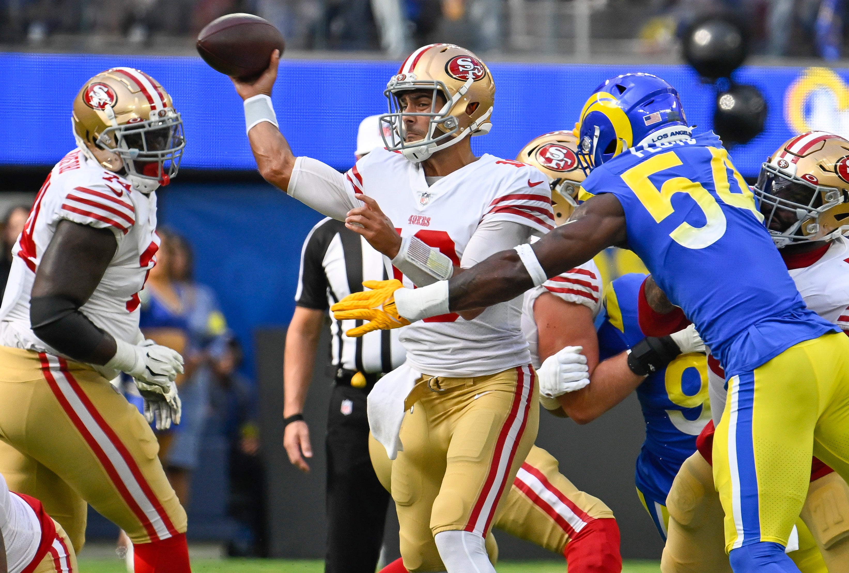 Oct 30, 2022; Inglewood, California, USA; San Francisco 49ers quarterback Jimmy Garoppolo (10) gets off a pass as Los Angeles Rams linebacker Leonard Floyd (54) tries for the sack during the first quarter at SoFi Stadium.
