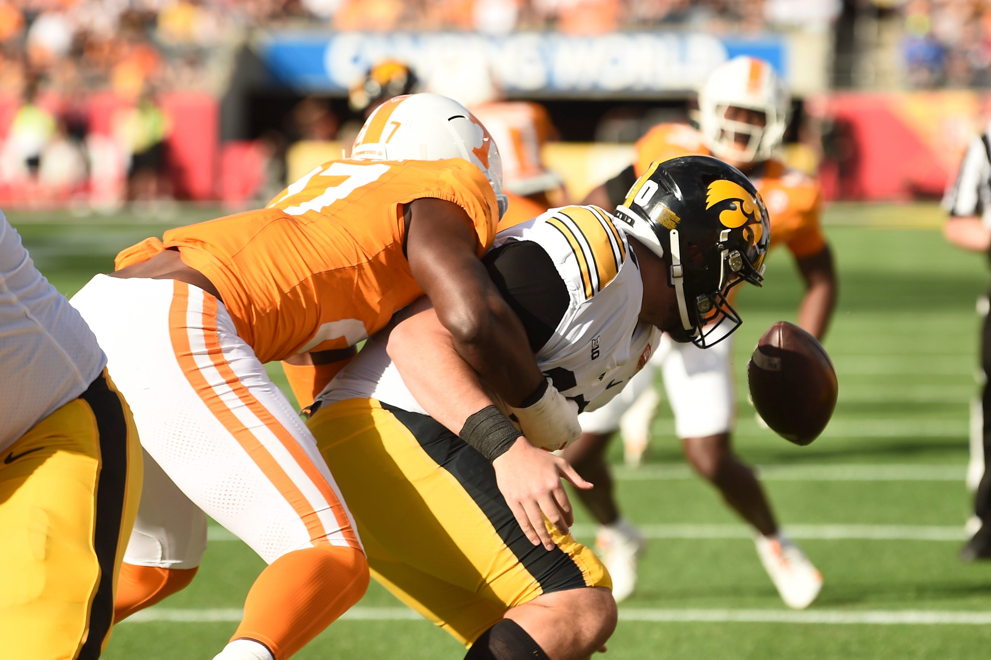 Citrus Bowl: Tennessee defensive lineman James Pearce Jr. (27) forces a fumble against Iowa quarterback Deacon Hill (10).