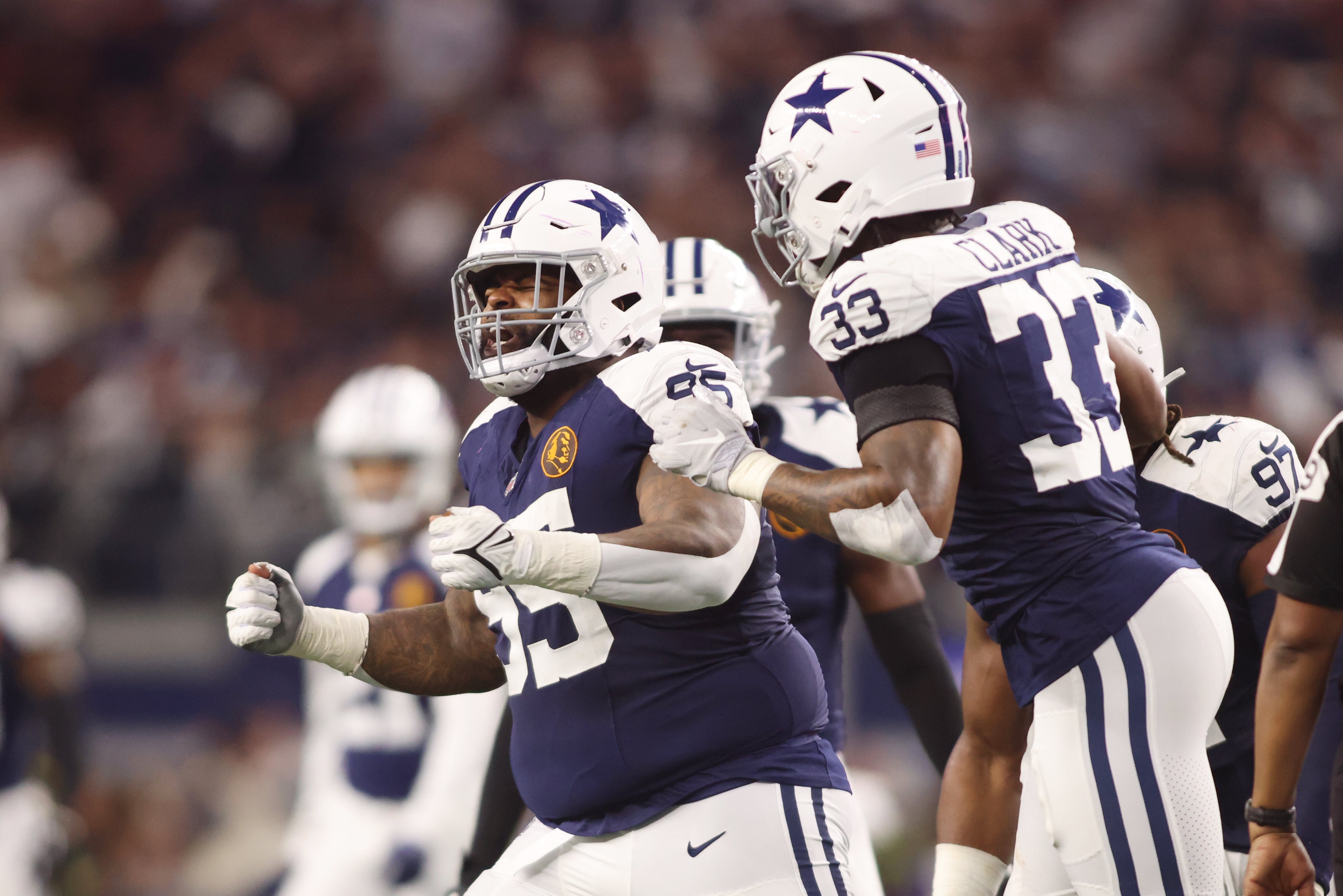Dallas Cowboys defensive tackle Johnathan Hankins (95) and linebacker Damone Clark (33) celebrate a sack in the fourth quarter against the Washington Commanders at AT&T Stadium.