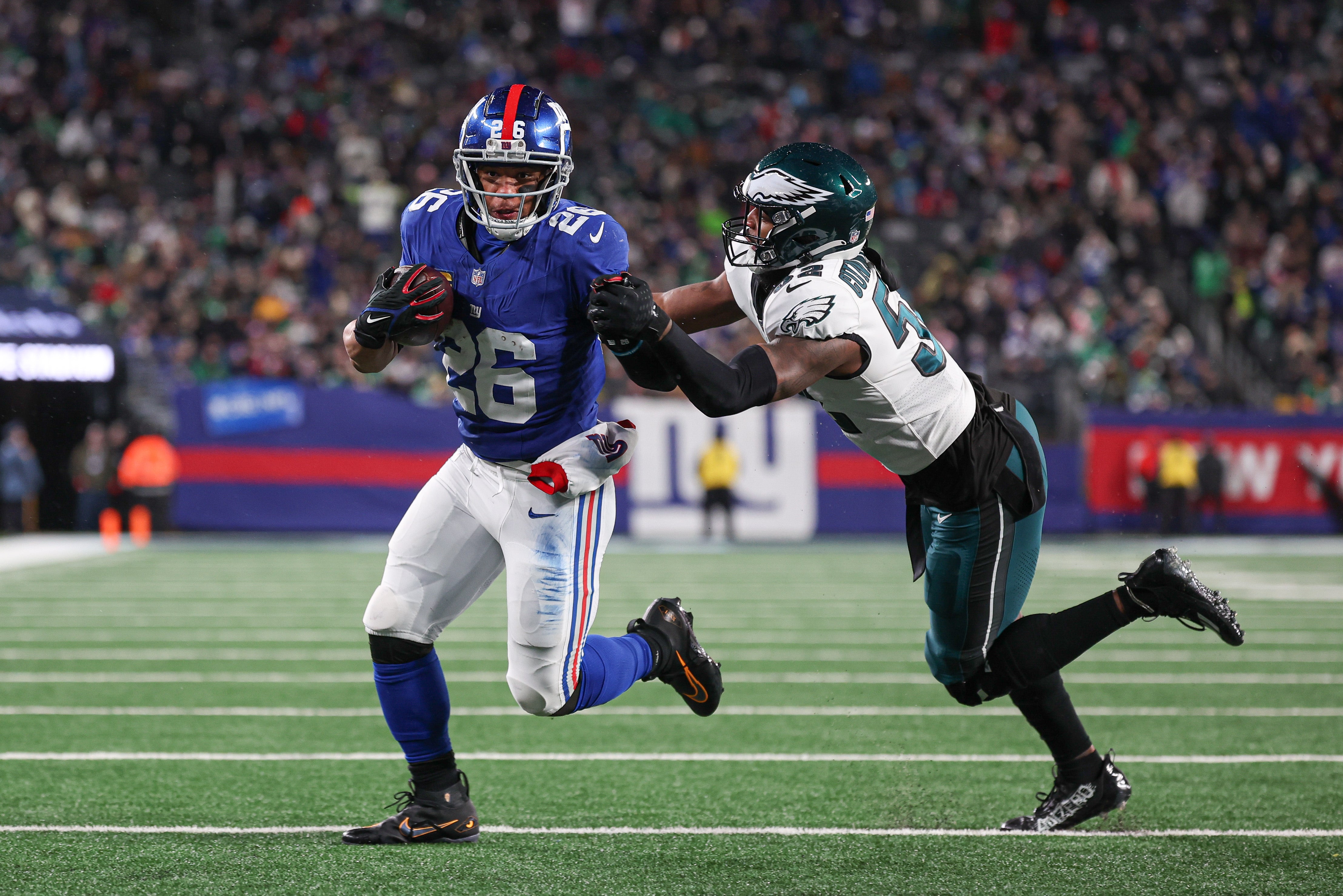 New York Giants running back Saquon Barkley (26) breaks a tackle by Philadelphia Eagles linebacker Zach Cunningham (52) for a rushing touchdown during the first half at MetLife Stadium.