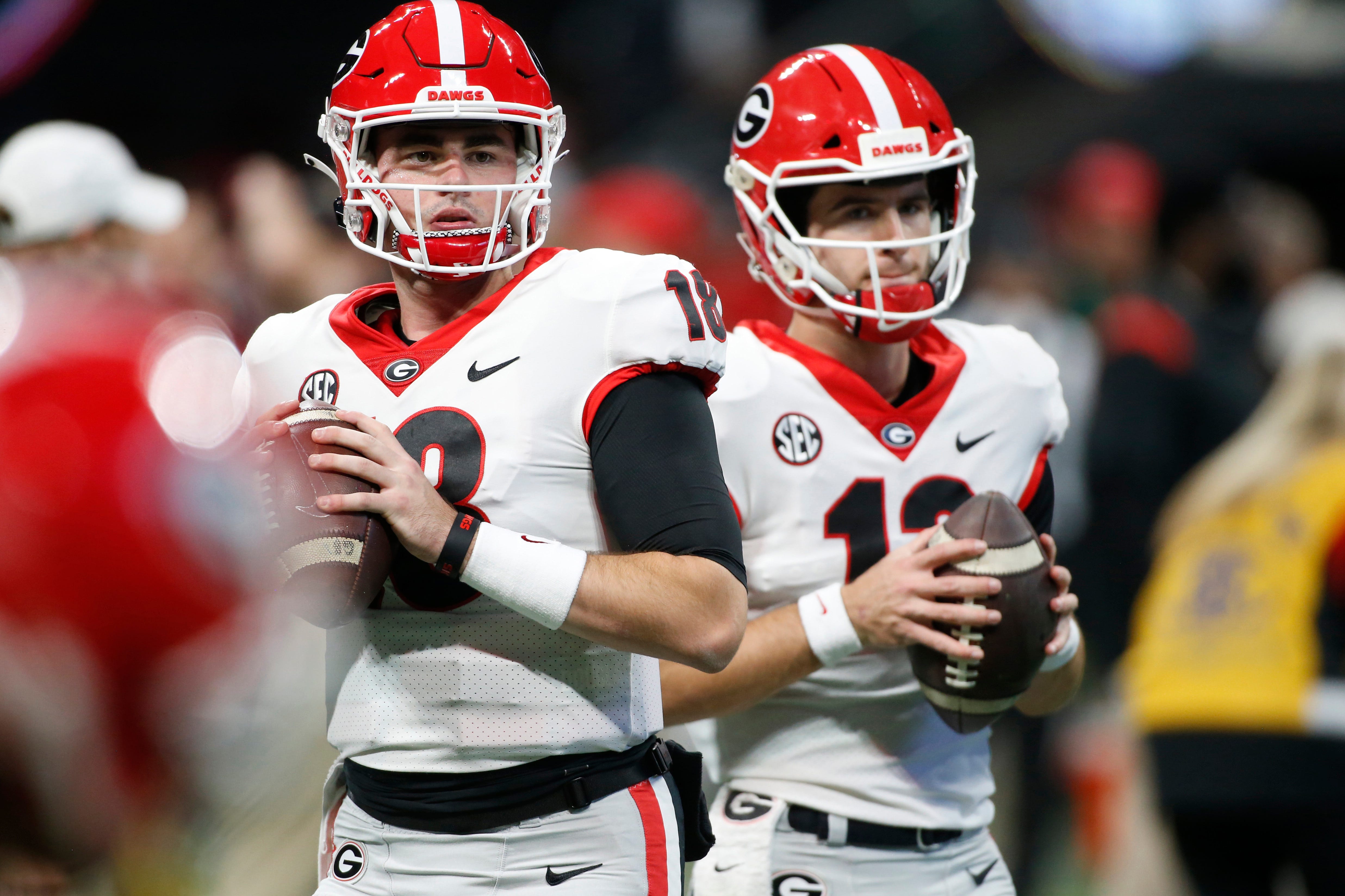 Georgia quarterbacks JT Daniels (18) and Stetson Bennett (13) warm up before the start the Southeastern Conference championship NCAA college football game between Georgia and Alabama in Atlanta, on Saturday, Dec. 4, 2021.