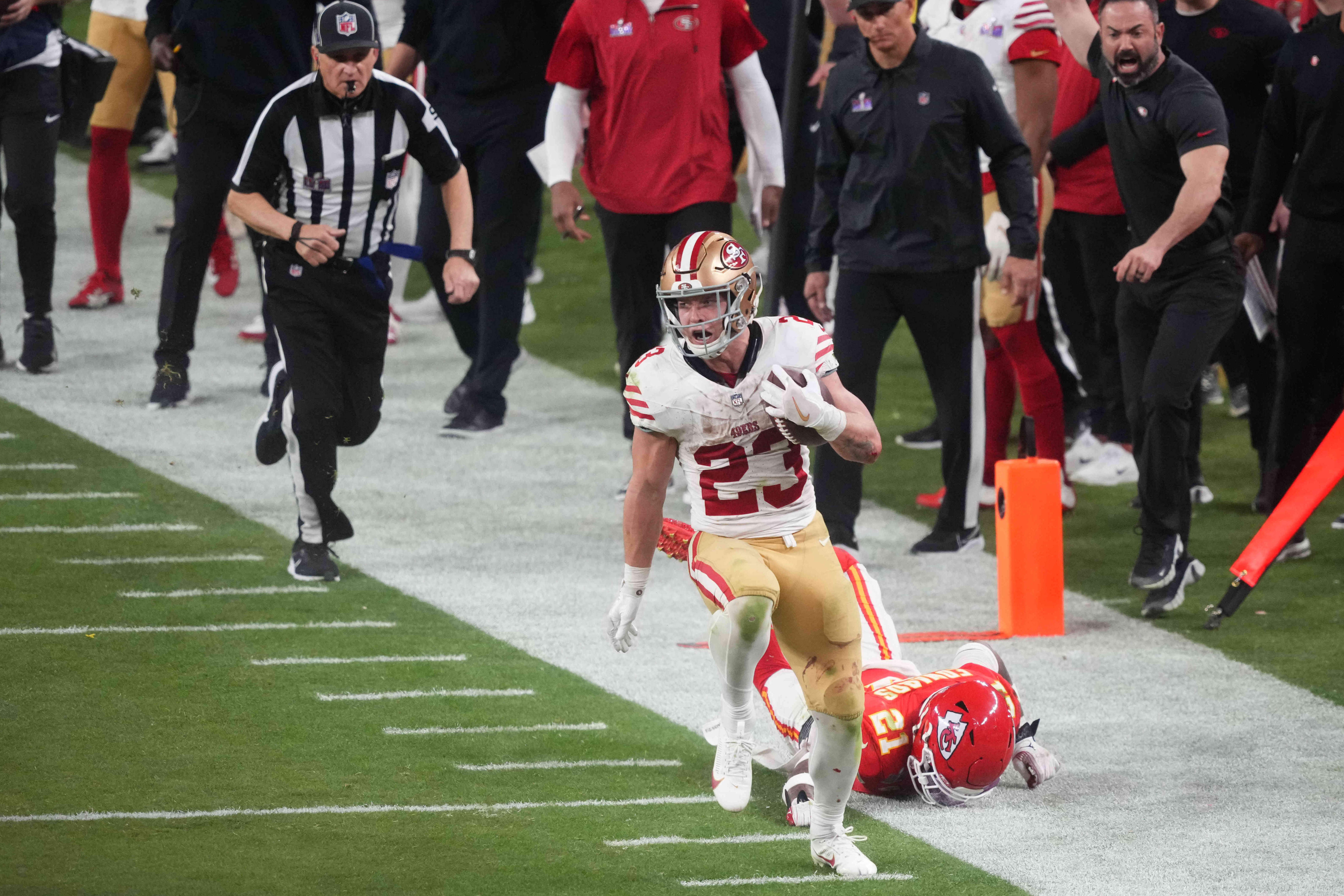 Feb 11, 2024; Paradise, Nevada, USA; San Francisco 49ers running back Christian McCaffrey (23) runs with the ball against Kansas City Chiefs safety Mike Edwards (21) during overtime of Super Bowl LVIII at Allegiant Stadium.