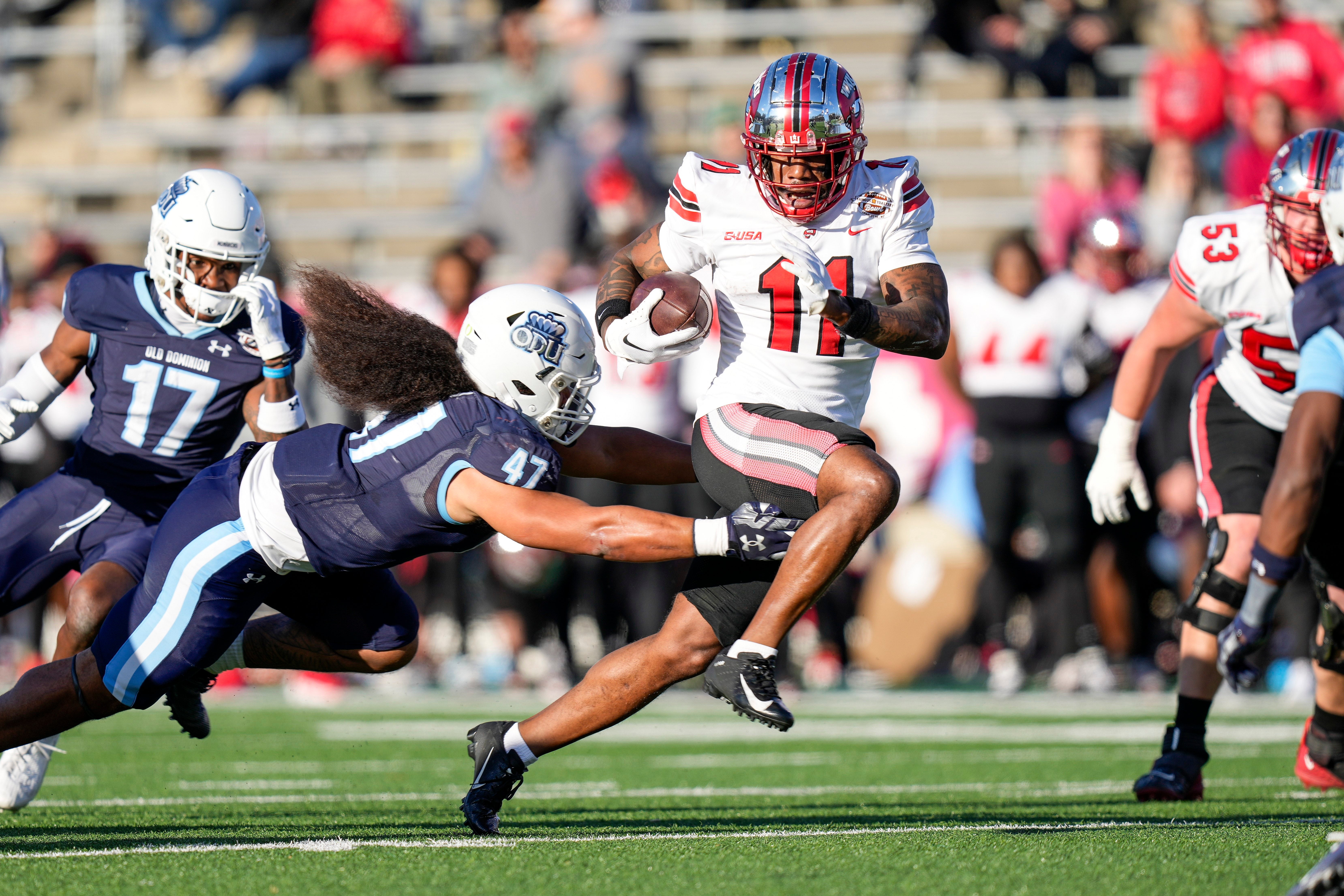 Dec 18, 2023; Charlotte, NC, USA; Western Kentucky Hilltoppers wide receiver Malachi Corley (11) runs the ball against Old Dominion Monarchs linebacker Koa Naotala (47) during the first quarter at Charlotte 49ers' Jerry Richardson Stadium.