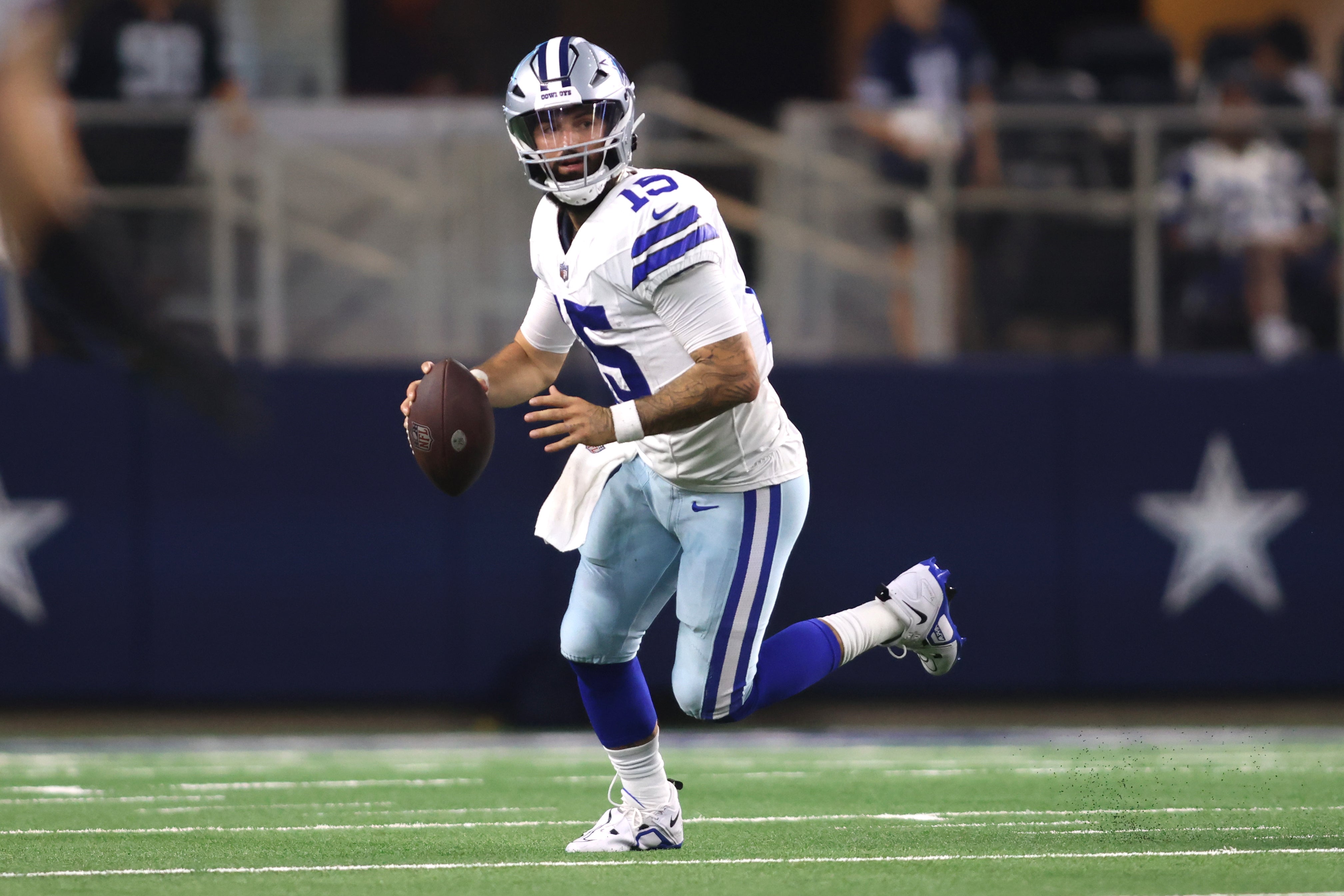 Dallas Cowboys quarterback Will Grier (15) rolls out in the second quarter against the Las Vegas Raiders at AT&T Stadium.