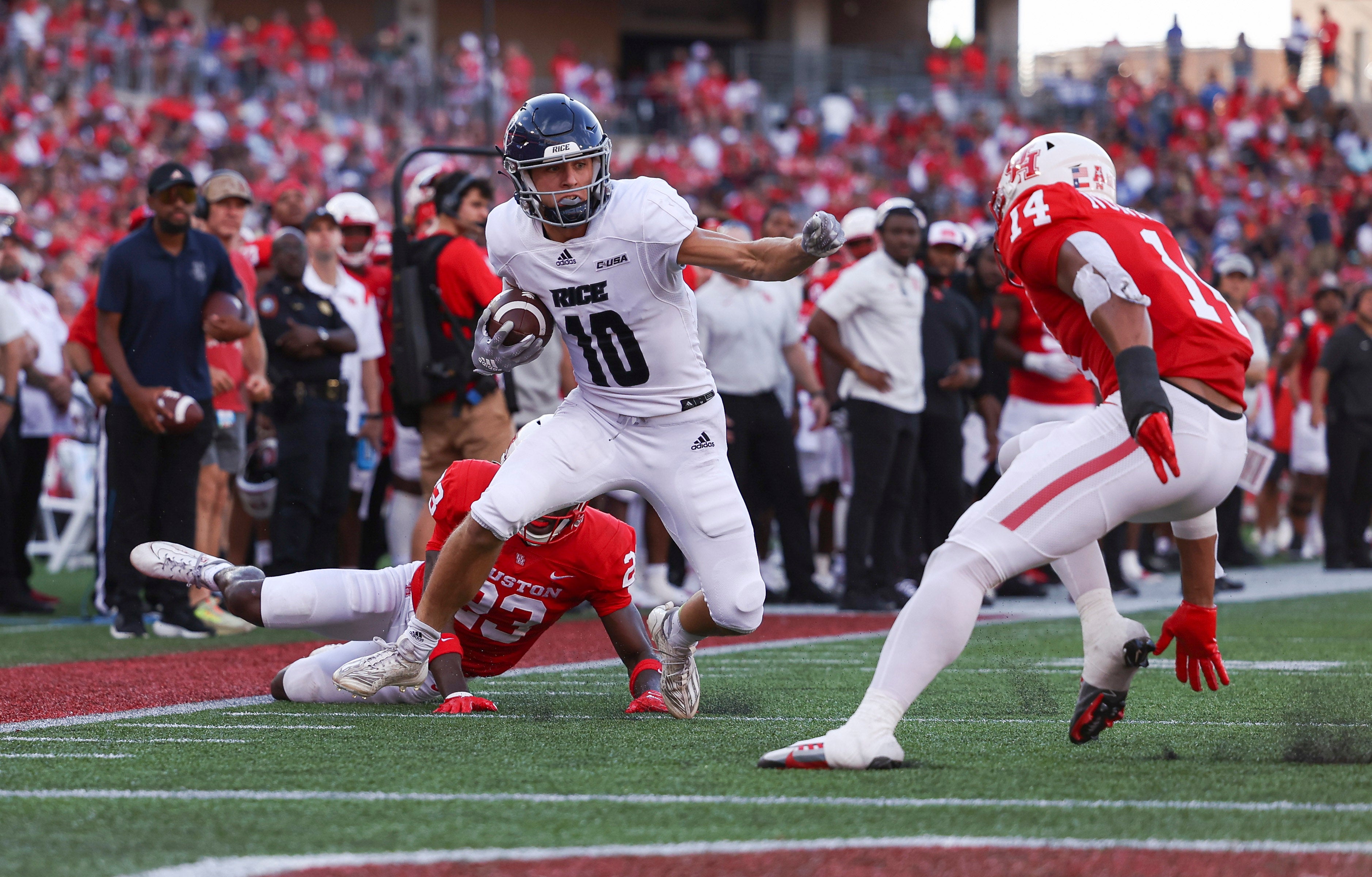 Rice Owls wide receiver Luke McCaffrey (10) runs with the ball as Houston Cougars linebacker Mannie Nunnery (14) defends during the second quarter at TDECU Stadium.