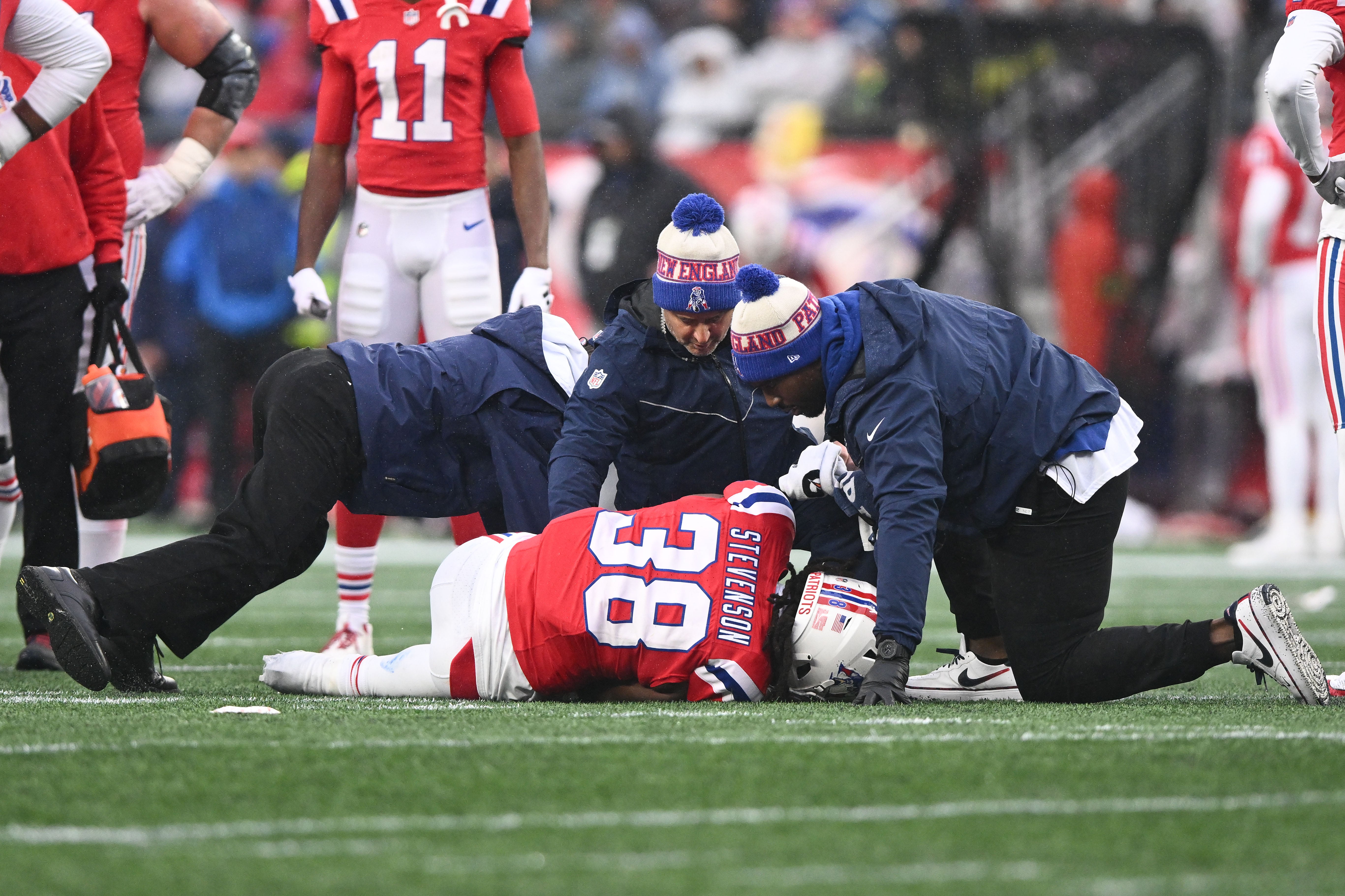 Caption: Dec 3, 2023; Foxborough, Massachusetts, USA; New England Patriots running back Rhamondre Stevenson (38) is helped by the athletic staff after an injury on a play against the Los Angeles Chargers during the first half at Gillette Stadium.