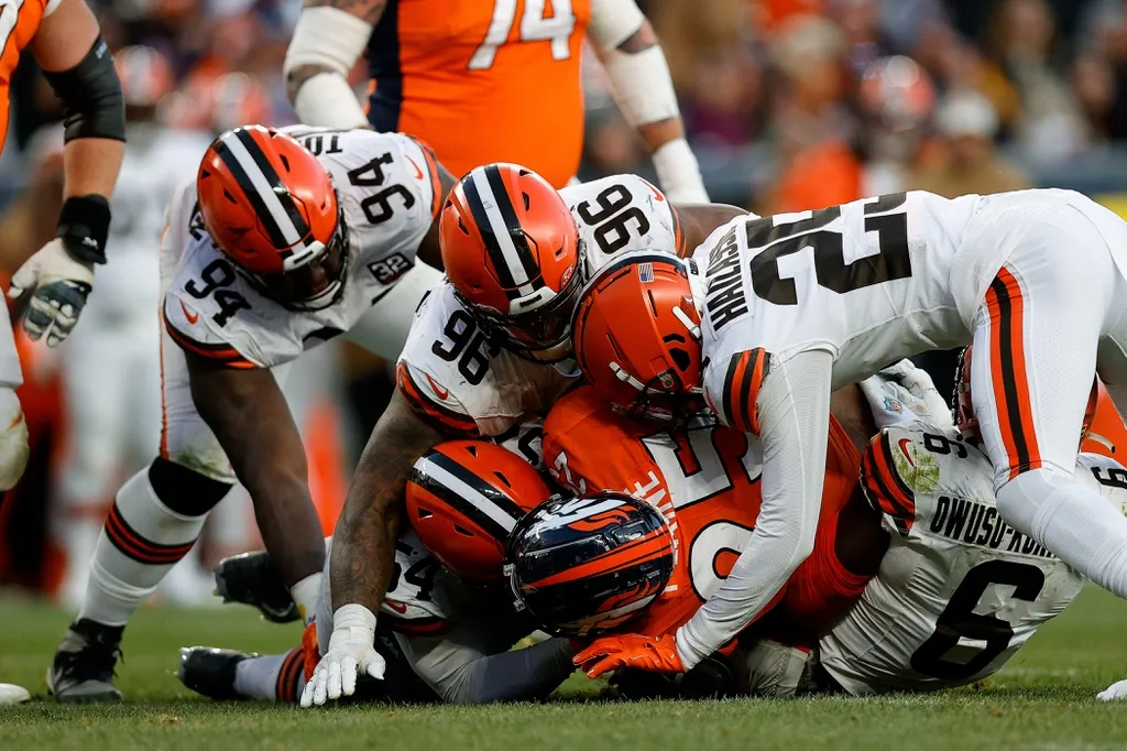 Denver Broncos running back Samaje Perine (25) is tackled by Cleveland Browns defensive end Ogbo Okoronkwo (54) and defensive tackle Dalvin Tomlinson (94) and defensive tackle Jordan Elliott (96) and ...