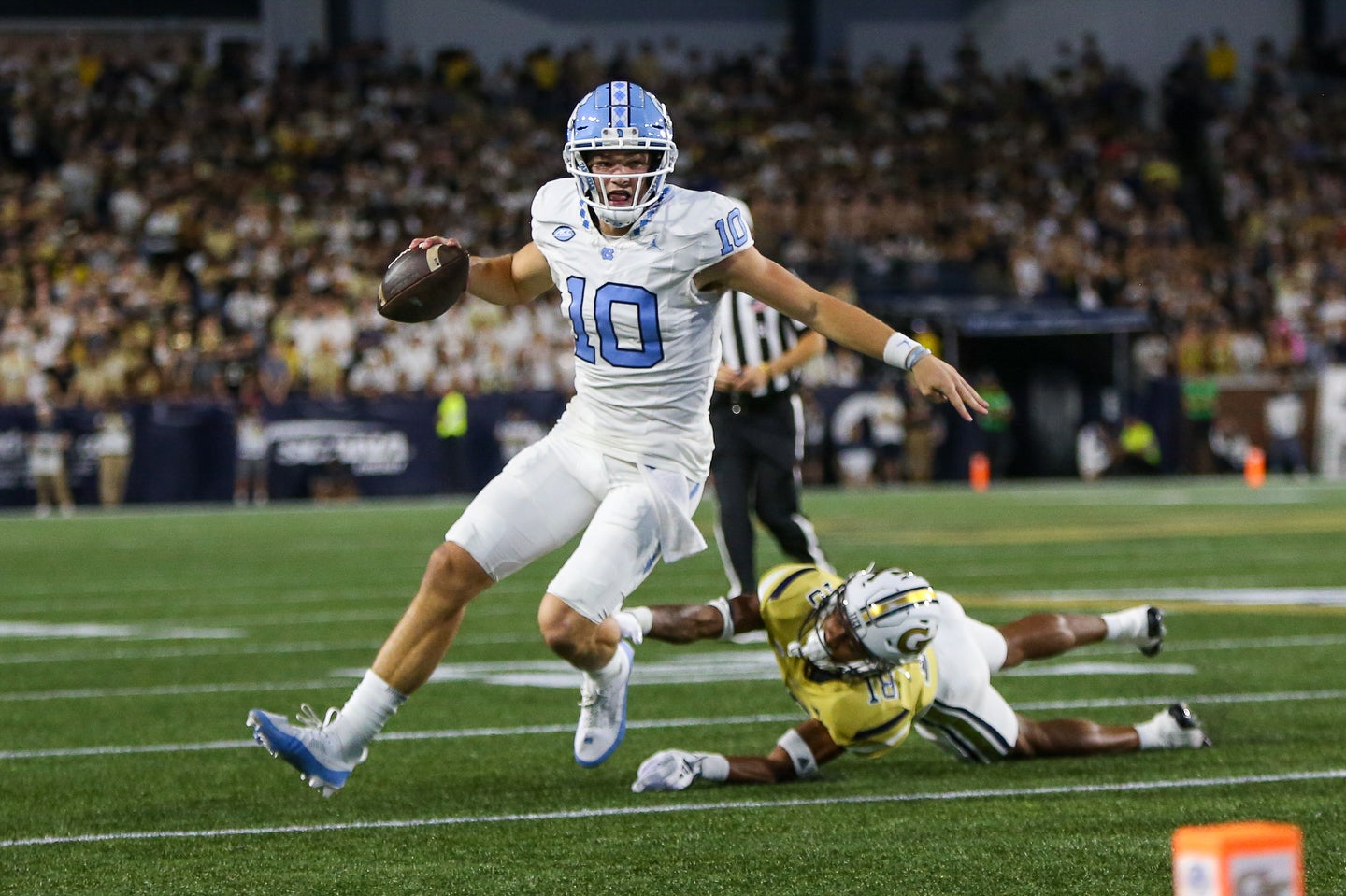 Oct 28, 2023; Atlanta, Georgia, USA; North Carolina Tar Heels quarterback Drake Maye (10) scrambles past Georgia Tech Yellow Jackets defensive back Ahmari Harvey (18) in the first half at Bobby Dodd Stadium at Hyundai Field.