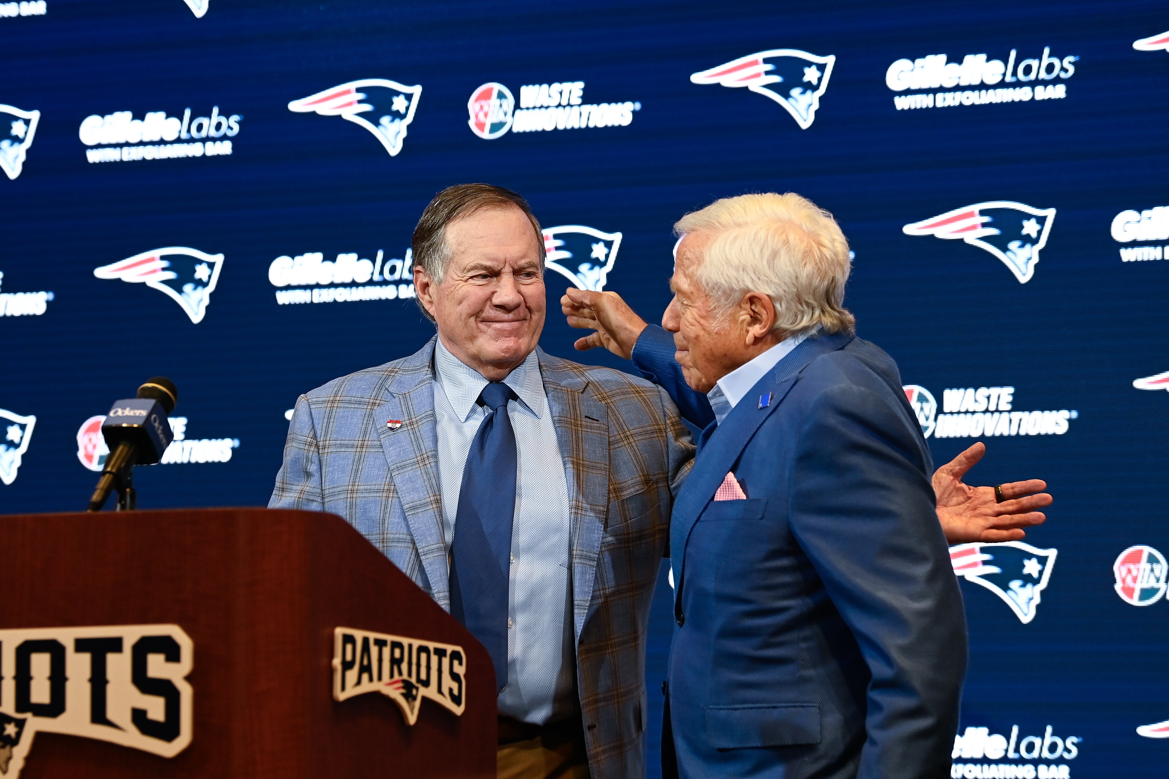 Jan 11, 2024; Foxborough, MA, USA; New England Patriots former head coach Bill Belichick (left) embraces Patriots owner Robert Kraft (right) during a press conference at Gillette Stadium to announce Belichick's exit from the team.