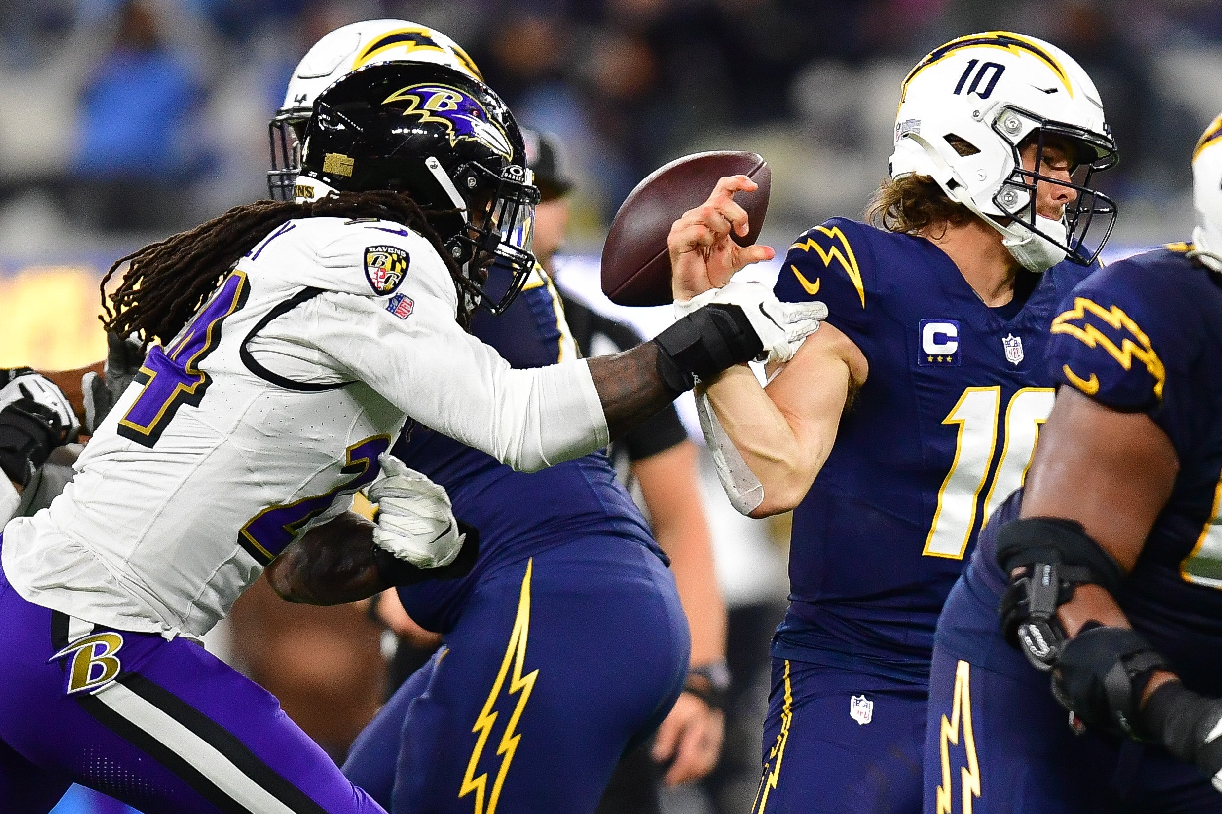 Nov 26, 2023; Inglewood, California, USA; Baltimore Ravens linebacker Jadeveon Clowney (24) strips the ball from Los Angeles Chargers quarterback Justin Herbert (10) during the second half at SoFi Stadium. Mandatory Credit: Gary A. Vasquez-USA TODAY Sports