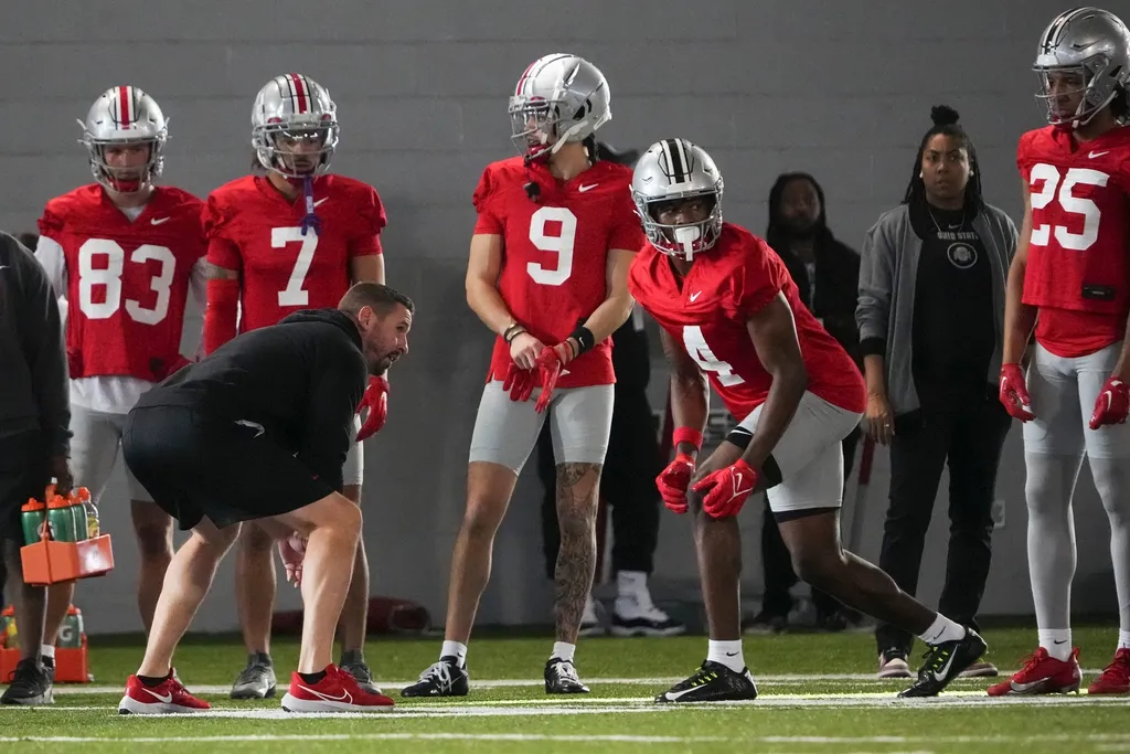 Ohio State Buckeyes offensive coordinator Brian Hartline lines up beside wide receiver Jeremiah Smith (4) during the first spring practice at the Woody Hayes Athletic Center
