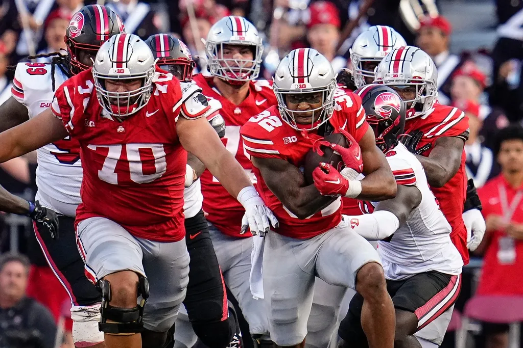 Ohio State Buckeyes running back TreVeyon Henderson (32) gets a block from offensive lineman Josh Fryar (70) during the second half of the NCAA football game against the Western Kentucky Hilltoppers a...