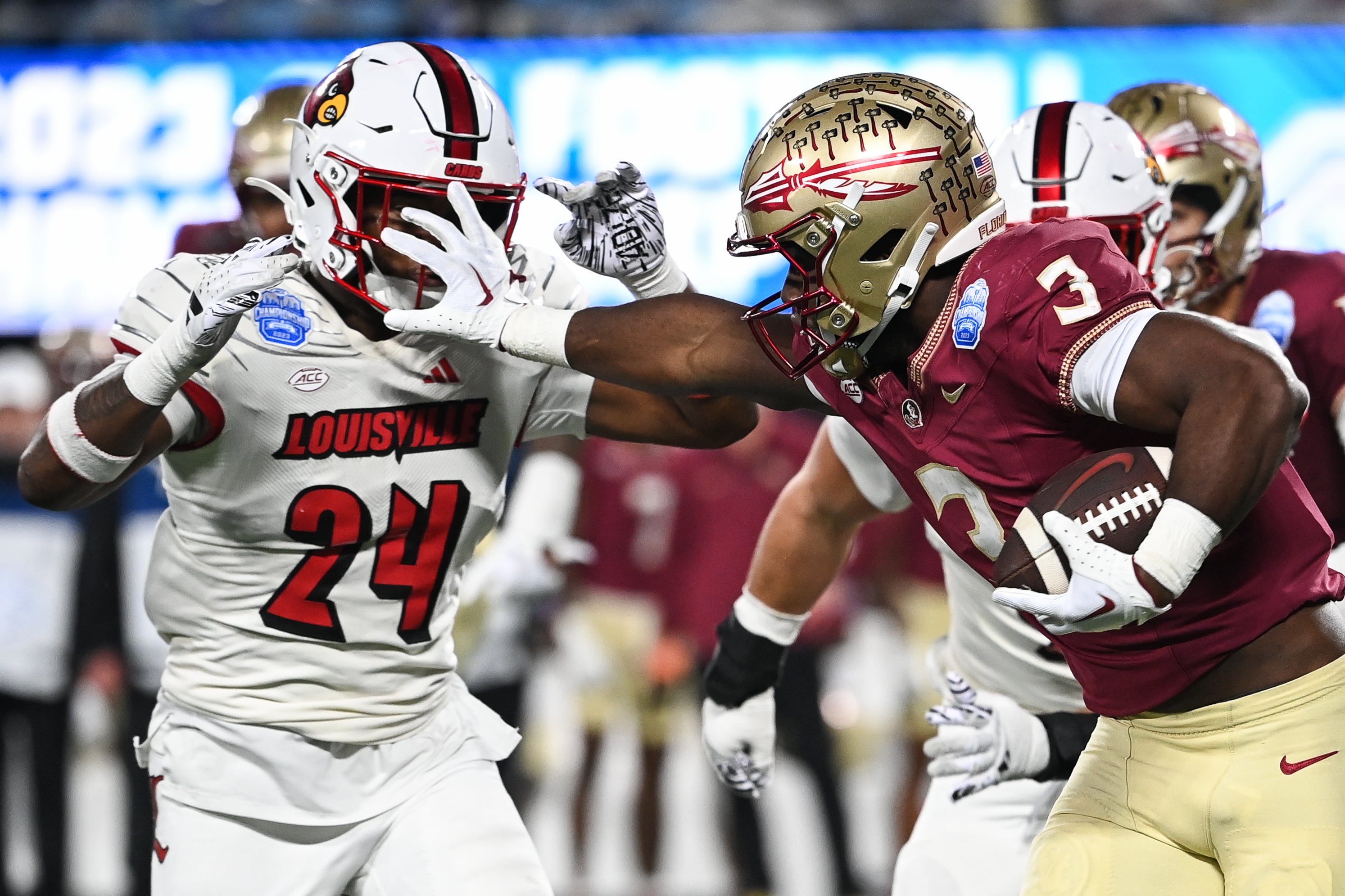 Dec 2, 2023; Charlotte, NC, USA; Florida State Seminoles running back Trey Benson (3) fends off Louisville Cardinals linebacker Jaylin Alderman (24) in the third quarter at Bank of America Stadium.