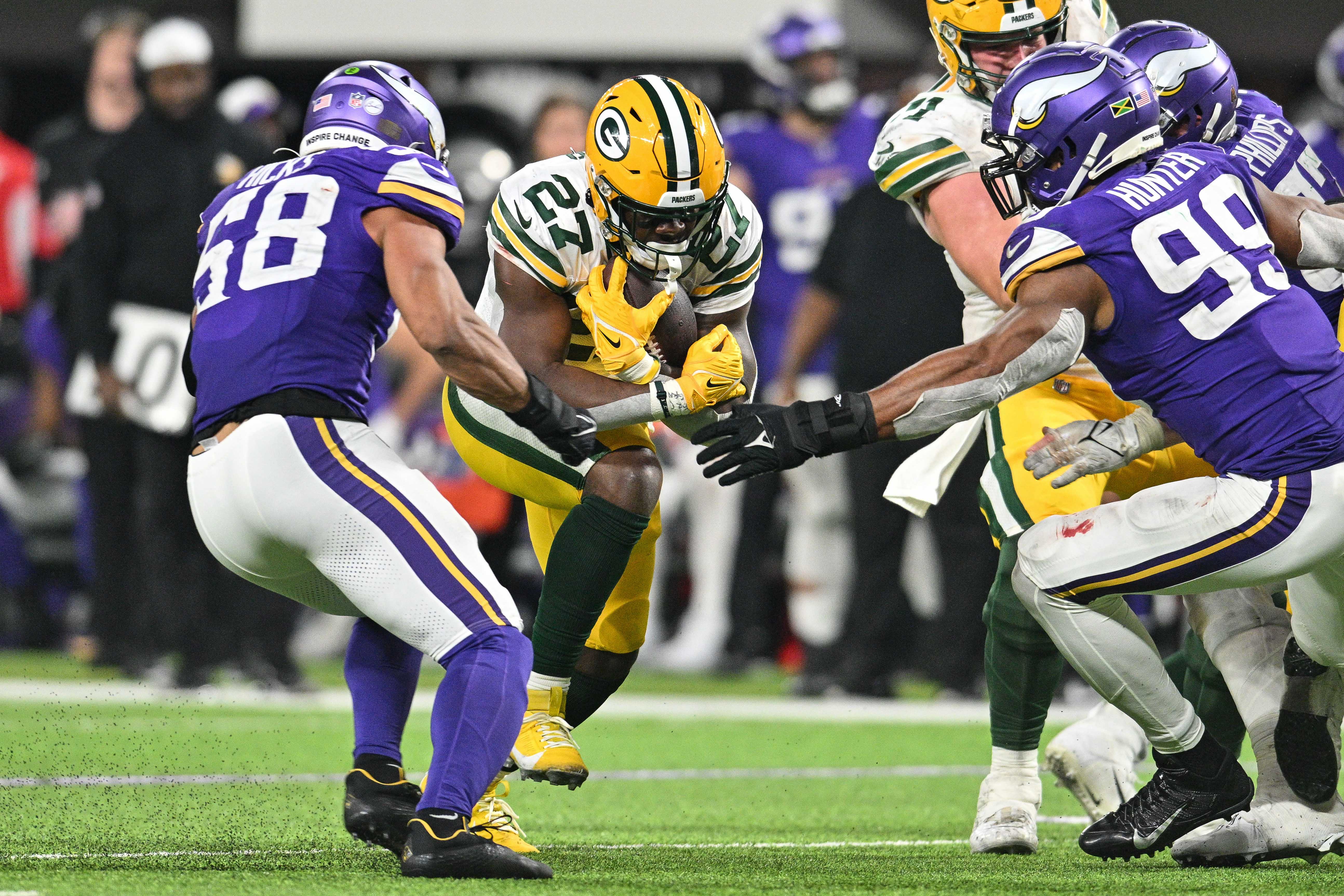 Dec 31, 2023; Minneapolis, Minnesota, USA; Green Bay Packers running back Patrick Taylor (27) runs the ball as Minnesota Vikings linebacker Jordan Hicks (58) and linebacker Danielle Hunter (99) move in for the tackle as center Josh Myers (71) blocks during the game at U.S. Bank Stadium.