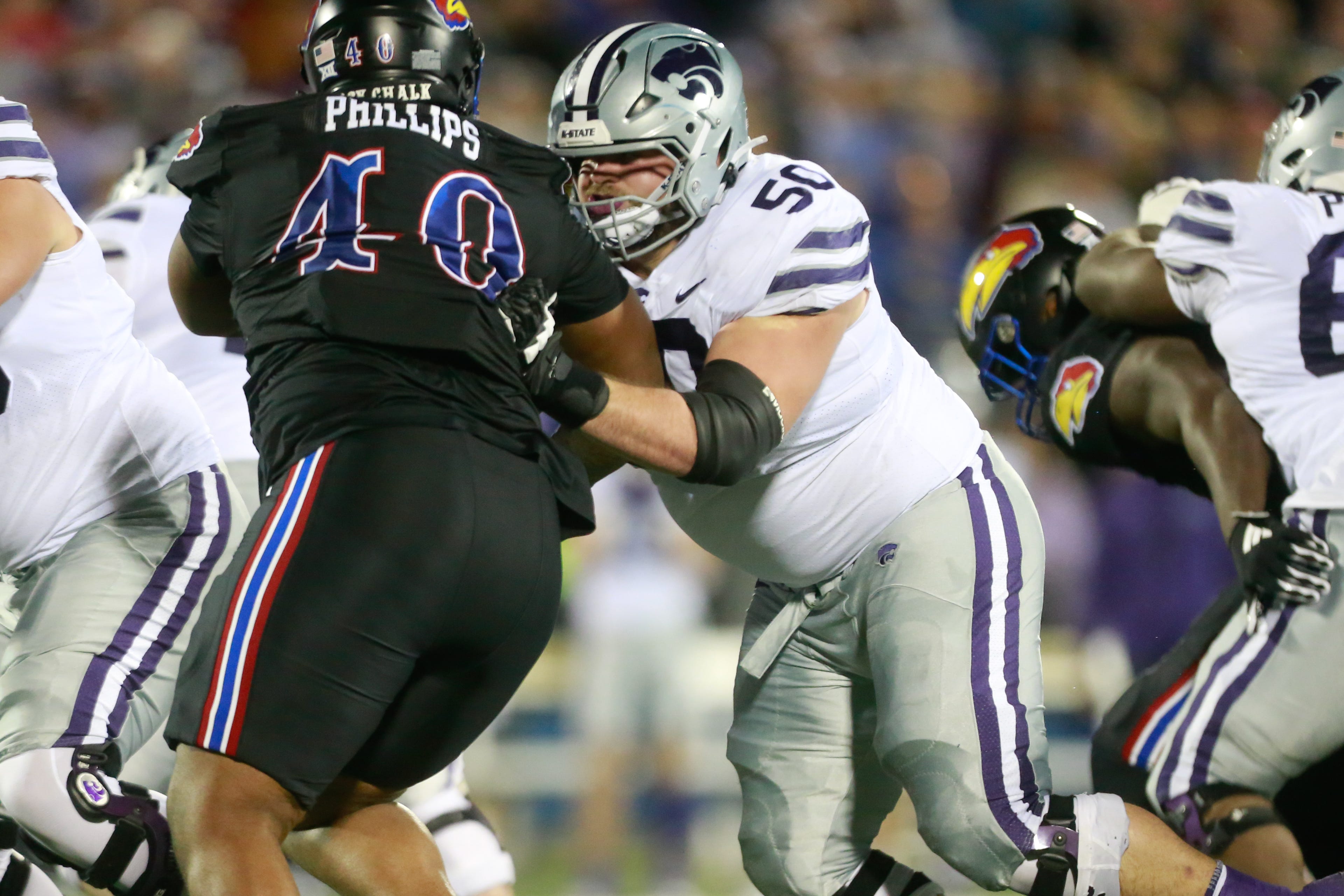 Kansas State senior offensive lineman cooper Beebe (50) keeps Kansas redshirt senior defensive lineman Devin Phillips (40) at bay during the second quarter of Saturday's Sunflower Showdown inside David Booth Kansas Memorial Stadium.