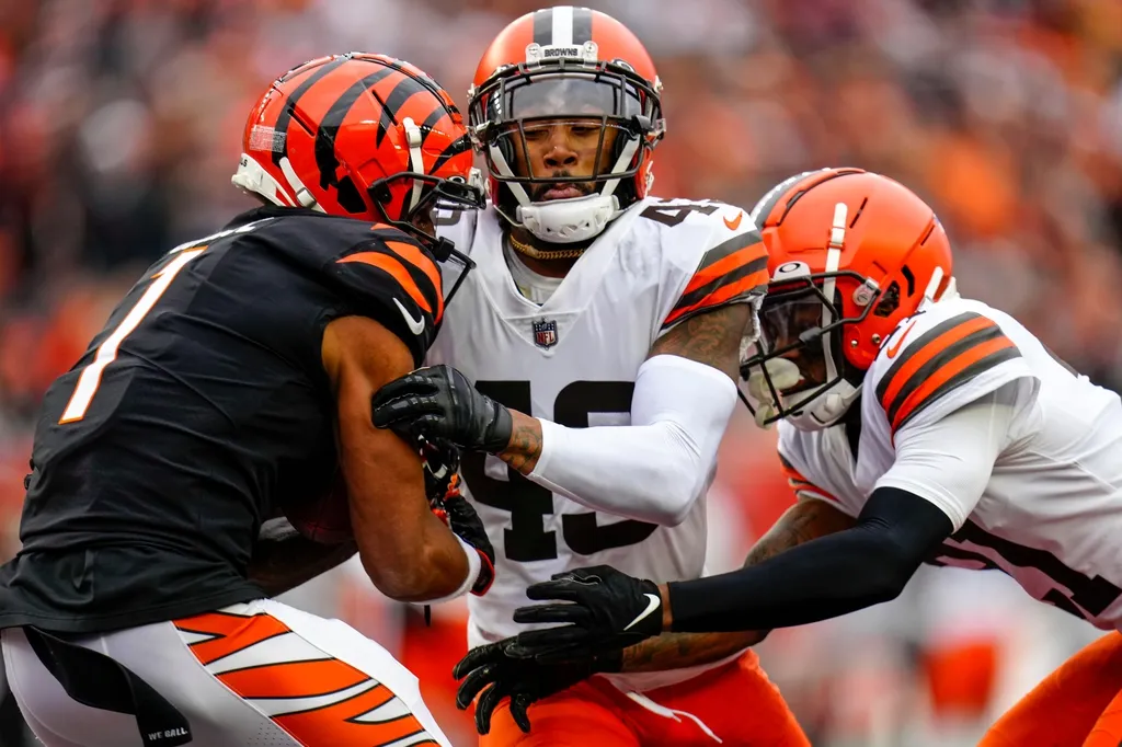 Cincinnati Bengals wide receiver Ja'Marr Chase (1) catches a pass under pressure from Cleveland Browns safety John Johnson III (43) and cornerback Denzel Ward (21) in the end zone for a touchdown in t...