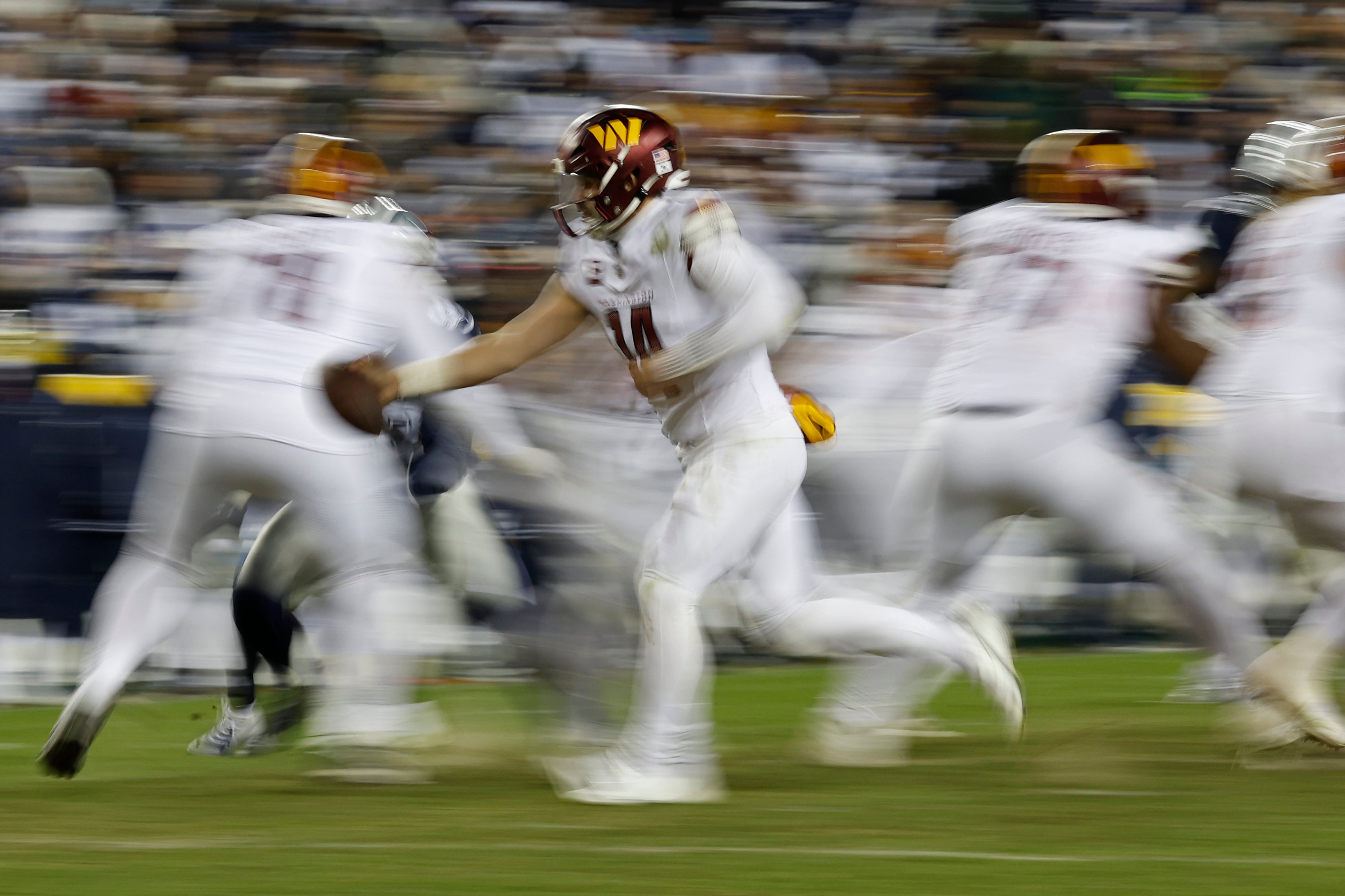 Jan 7, 2024; Landover, Maryland, USA; Washington Commanders quarterback Sam Howell (14) hands the ball off against the Dallas Cowboys during the fourth quarter at FedExField. Mandatory Credit: Geoff Burke-USA TODAY Sports