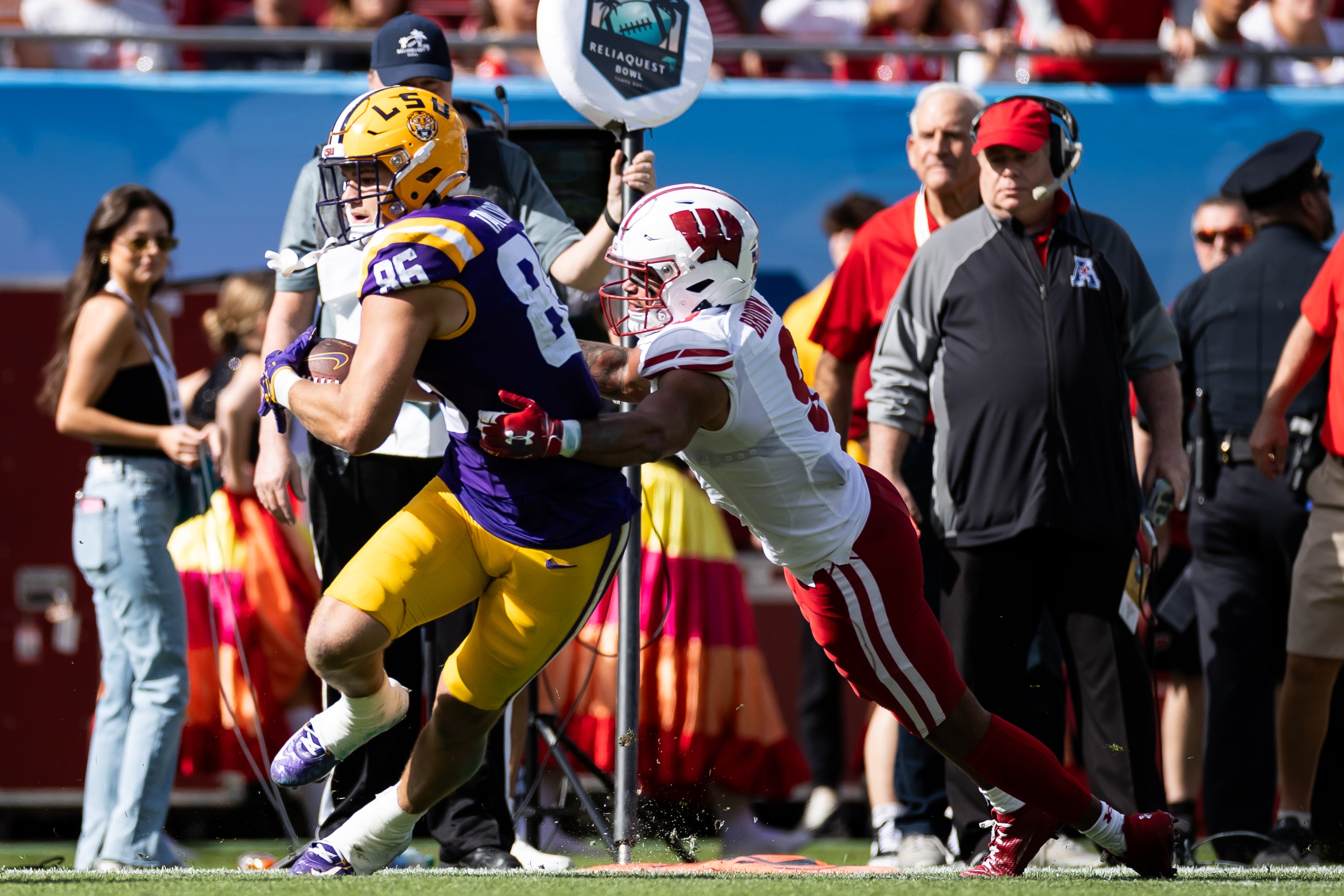 Jan 1, 2024; Tampa, FL, USA; Wisconsin Badgers safety Austin Brown (9) tackles LSU Tigers tight end Mason Taylor (86) during the first half at Raymond James Stadium.