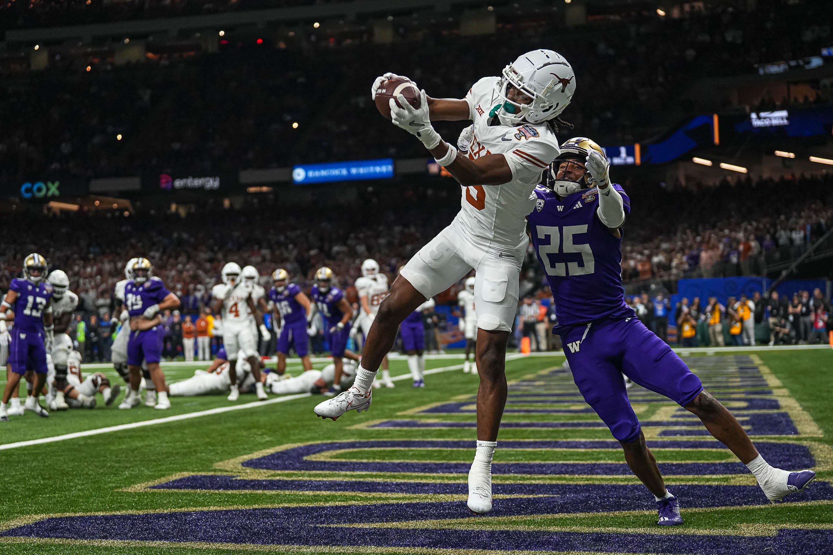 Texas Longhorns wide receiver Adonai Mitchell (5) makes a touchdown catch over Washington cornerback Elijah Jackson during the Sugar Bowl College Football Playoff semifinals game at the Caesars Superdome on Monday, Jan. 1, 2024 in New Orleans, Louisiana. The catch would be the last touchdown for the Longhorns in the 31-37 loss to Washington