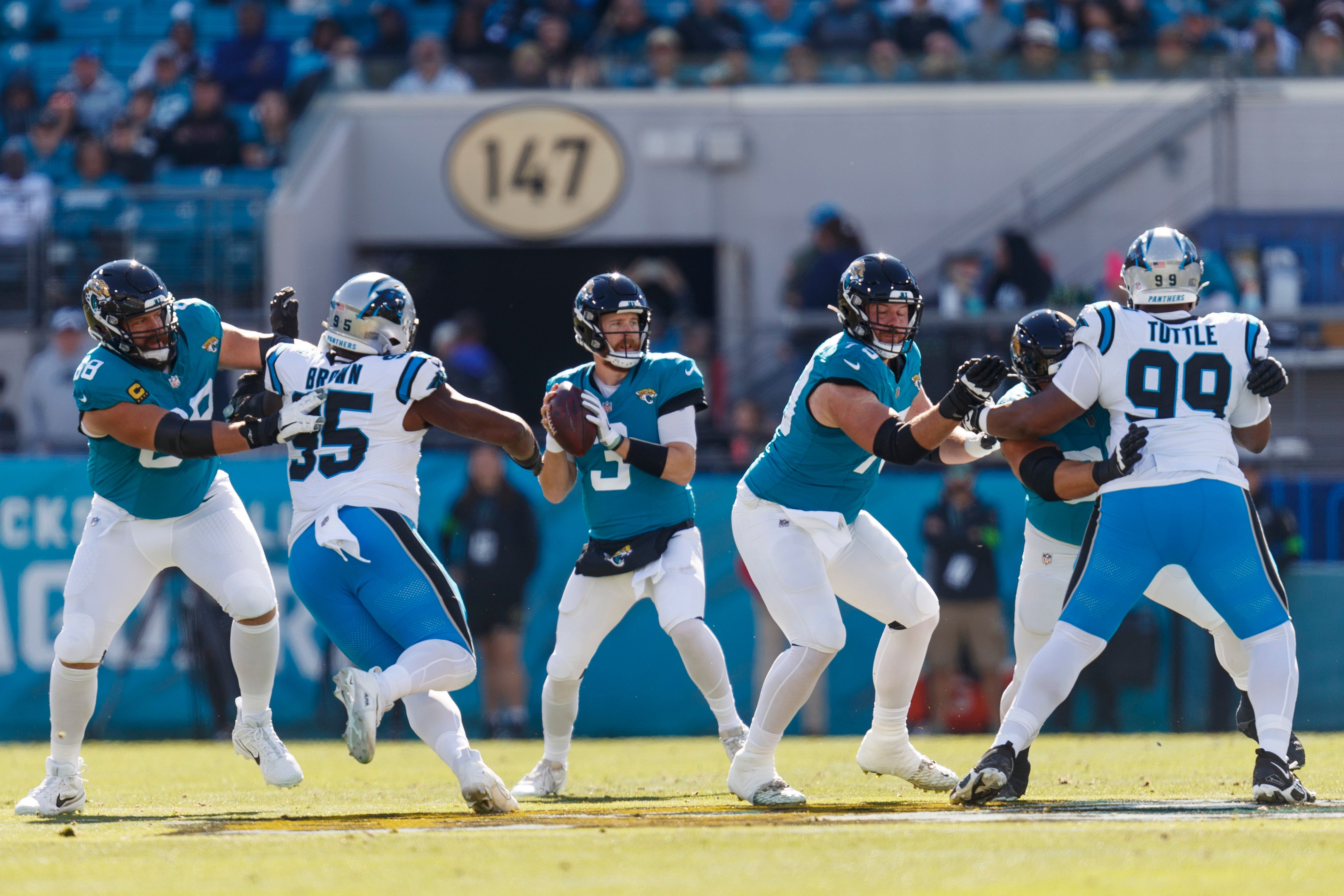 Dec 31, 2023; Jacksonville, Florida, USA; Jacksonville Jaguars quarterback C.J. Beathard (3) looks for a pass beyond offensive line as Carolina Panthers defensive tackle Derrick Brown (95) closes in during the first quarter during the first quarter at EverBank Stadium. Mandatory Credit: Morgan Tencza-USA TODAY Sports