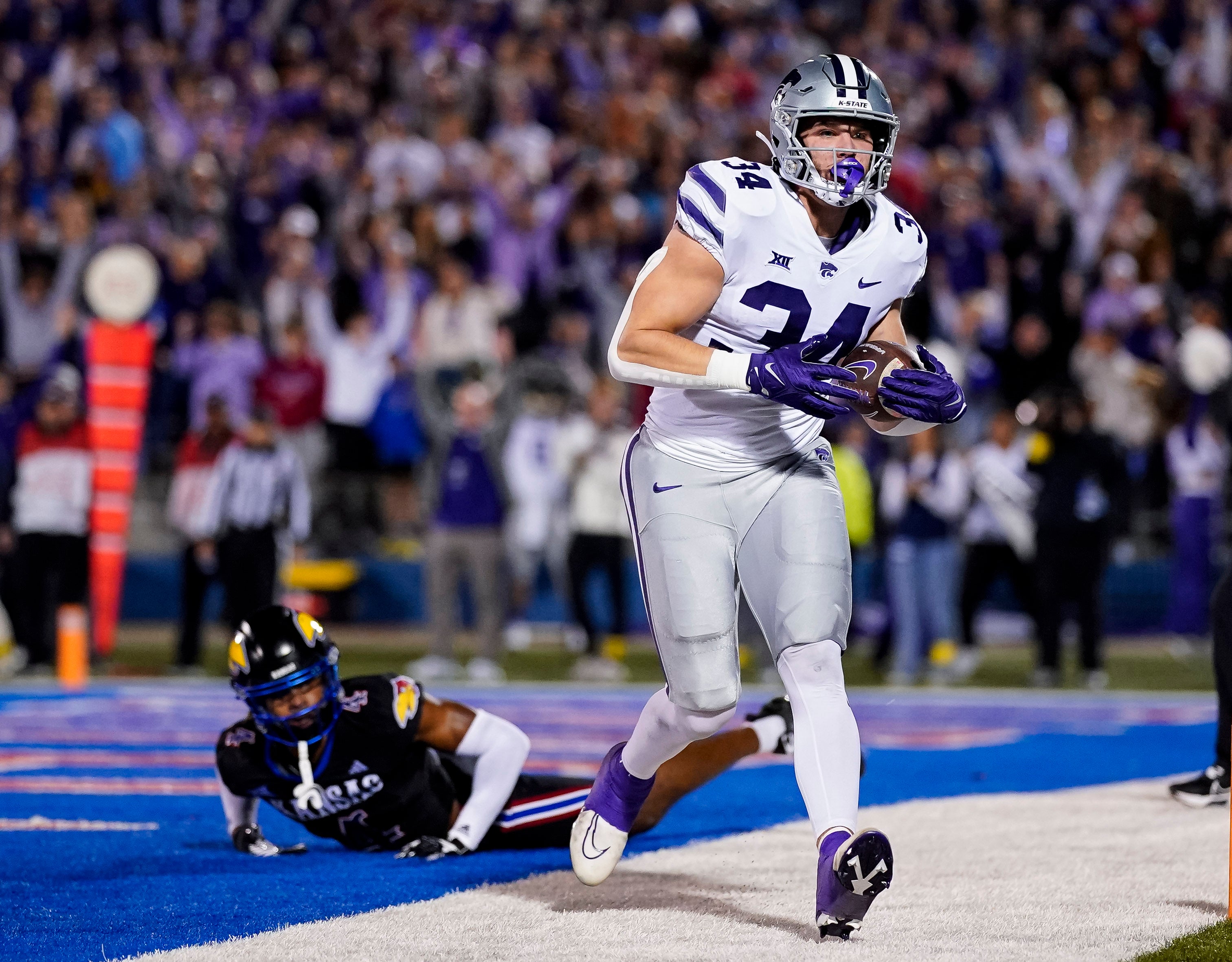 Nov 18, 2023; Lawrence, Kansas, USA; Kansas State Wildcats tight end Ben Sinnott (34) catches a touchdown pass against Kansas Jayhawks safety Marvin Grant (4) during the first half at David Booth Kansas Memorial Stadium.