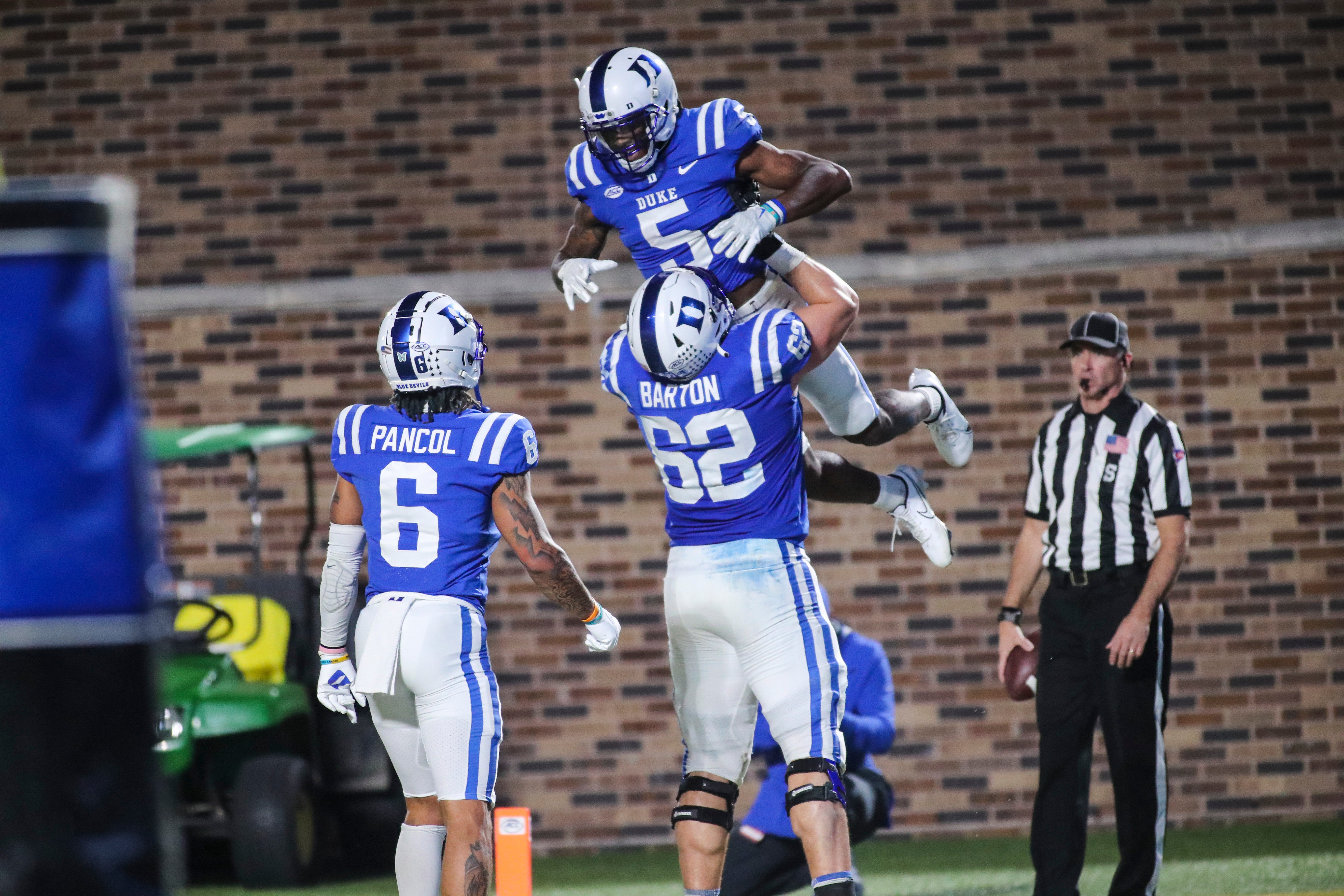 Nov 18, 2021; Durham, North Carolina, USA; Duke Blue Devils offensive tackle Graham Barton (62) holds wide receiver Jalon Calhoun (5) as they celebrate a touchdown with wide receiver Eli Pancol (6) during the 2nd half of the game against the Louisville Cardinals at Wallace Wade Stadium. Mandatory Credit: Jaylynn Nash-USA TODAY Sports