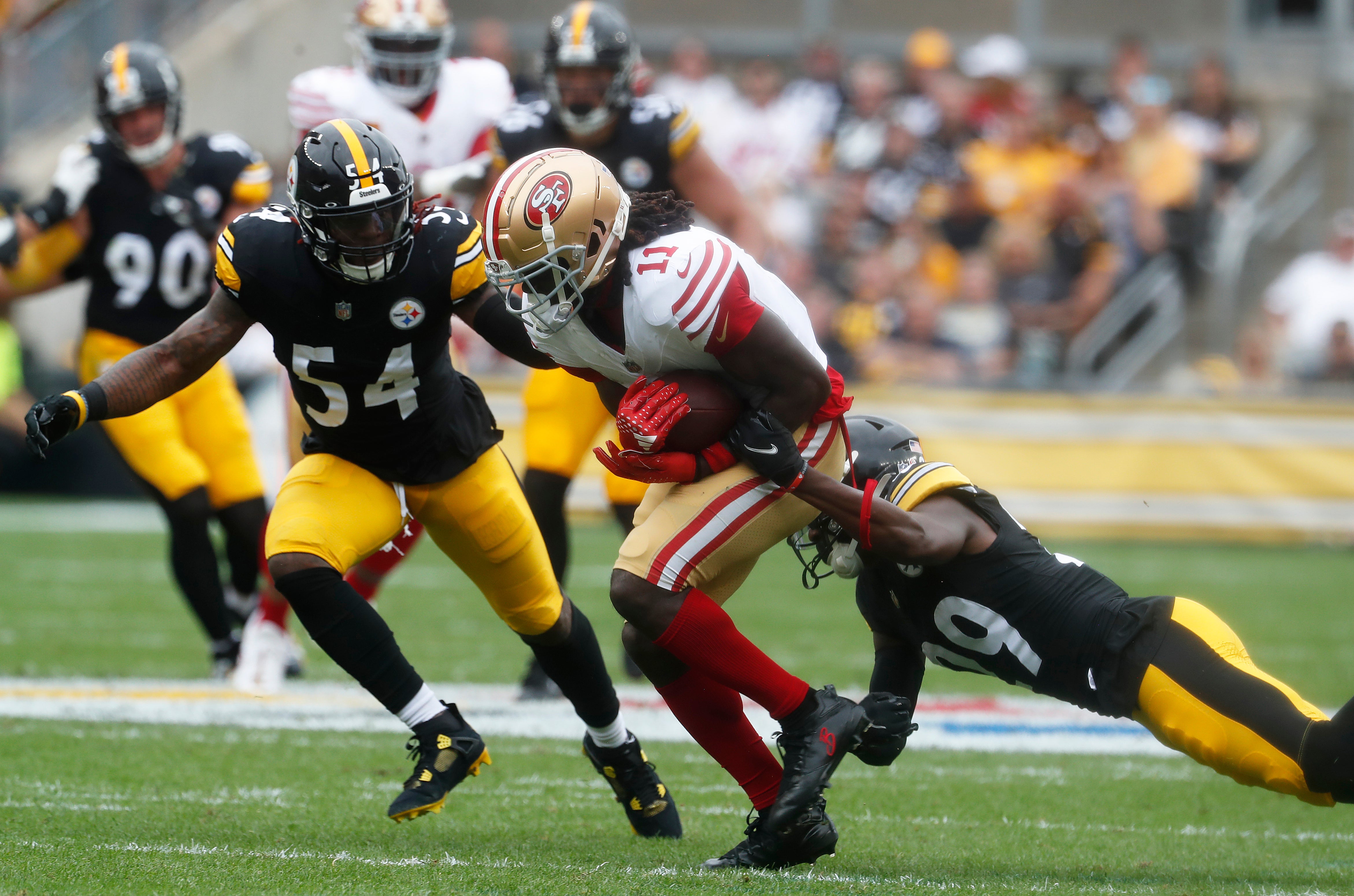 Sep 10, 2023; Pittsburgh, Pennsylvania, USA; San Francisco 49ers wide receiver Brandon Aiyuk (11) runs after a catch as Pittsburgh Steelers linebacker Kwon Alexander (54) and cornerback Levi Wallace (29) defend during the second quarter against at Acrisure Stadium. Mandatory Credit: Charles LeClaire-USA TODAY Sports