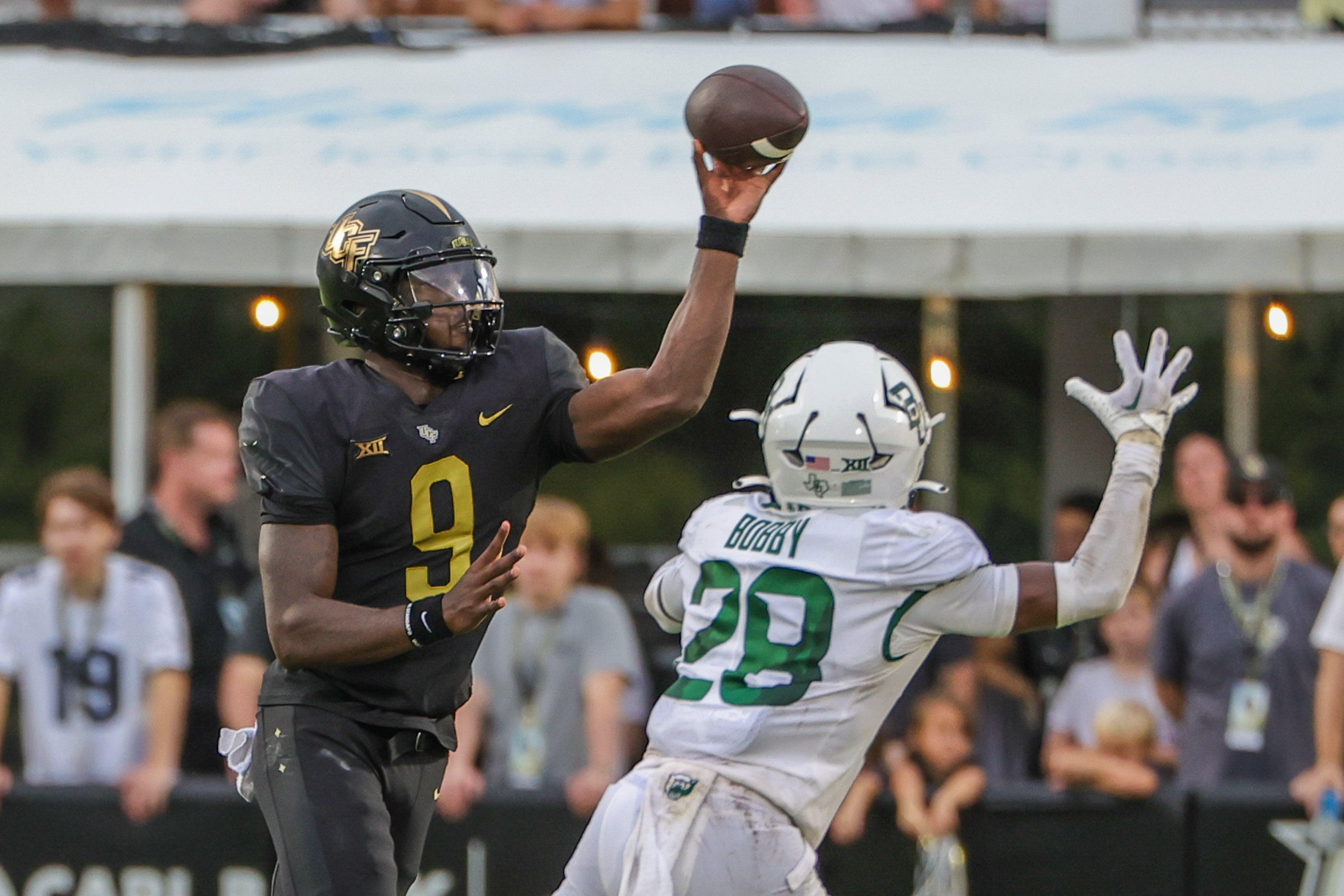 Sep 30, 2023; Orlando, Florida, USA; UCF Knights quarterback Timmy McClain (9) throws a pass in front of Baylor Bears safety Devyn Bobby (28) during the second half at FBC Mortgage Stadium.
