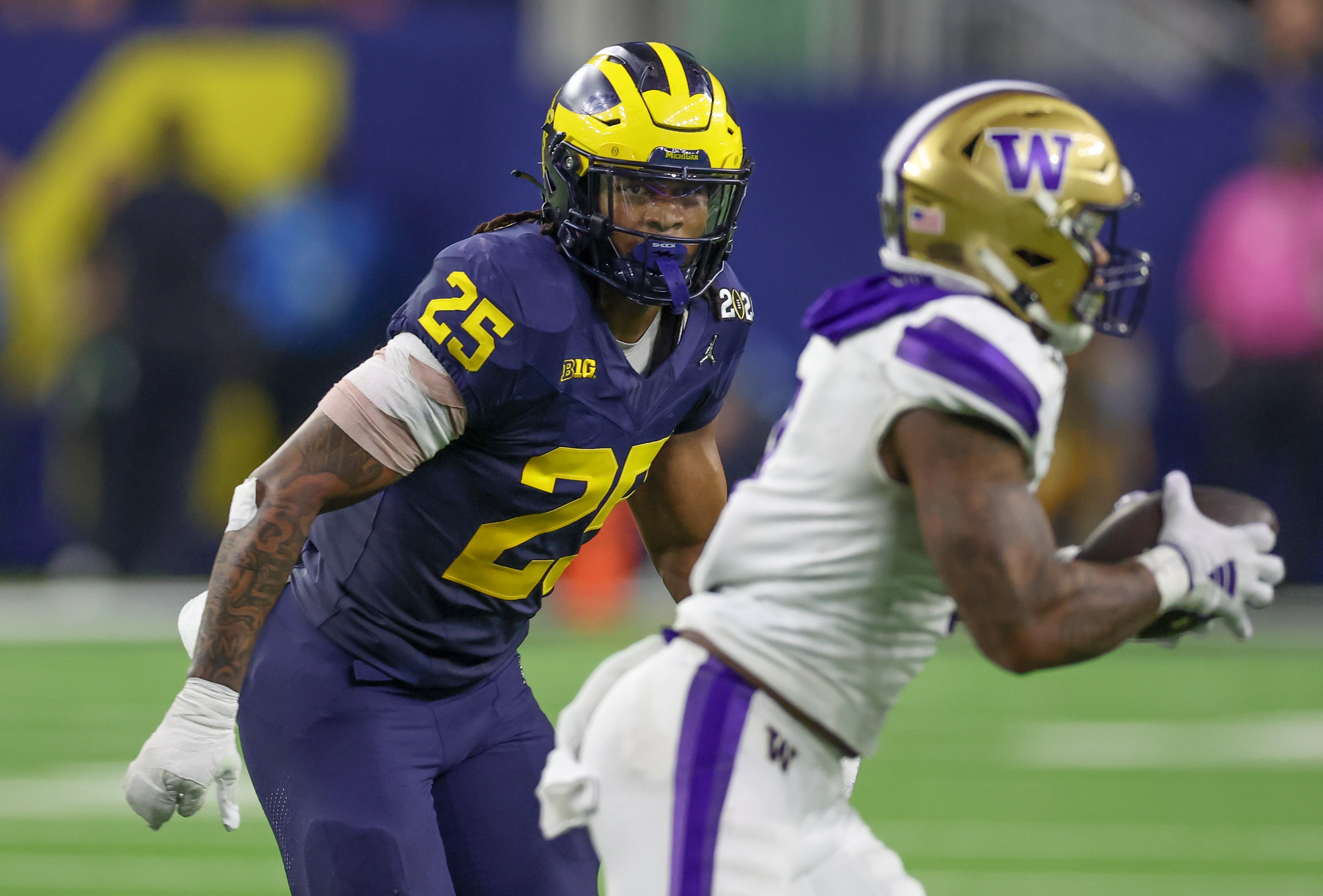 Jan 8, 2024; Houston, TX, USA;Washington Huskies quarterback Michael Penix Jr. (9) is chased by Michigan Wolverines linebacker Junior Colson (25) in the 2024 College Football Playoff national championship game at NRG Stadium. Mandatory Credit: Thomas Shea-USA TODAY Sports  