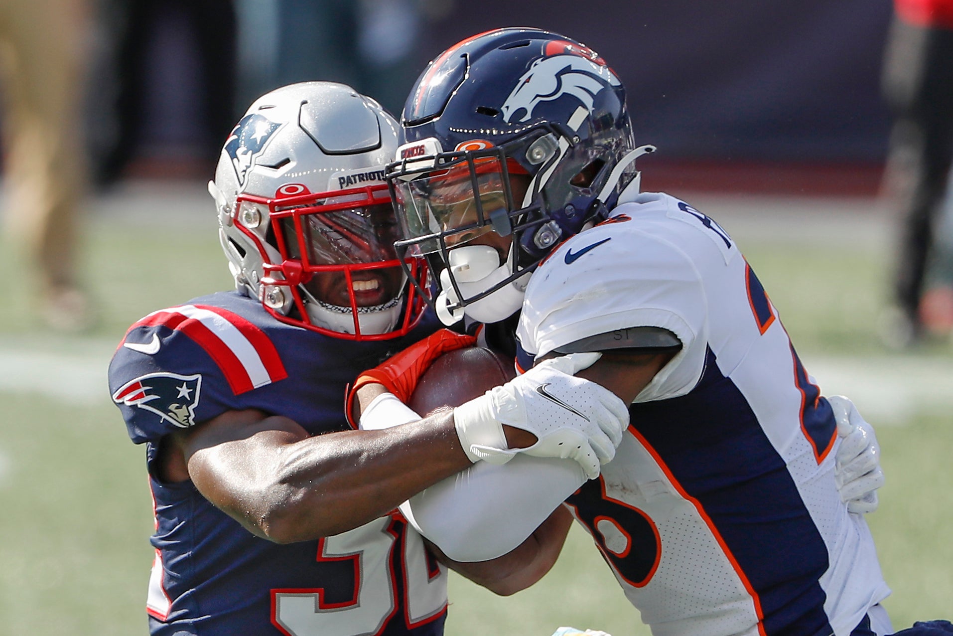 Denver Broncos running back Royce Freeman (right) runs against New England Patriots cornerback Jason McCourty (30) during the first quarter at Gillette Stadium.