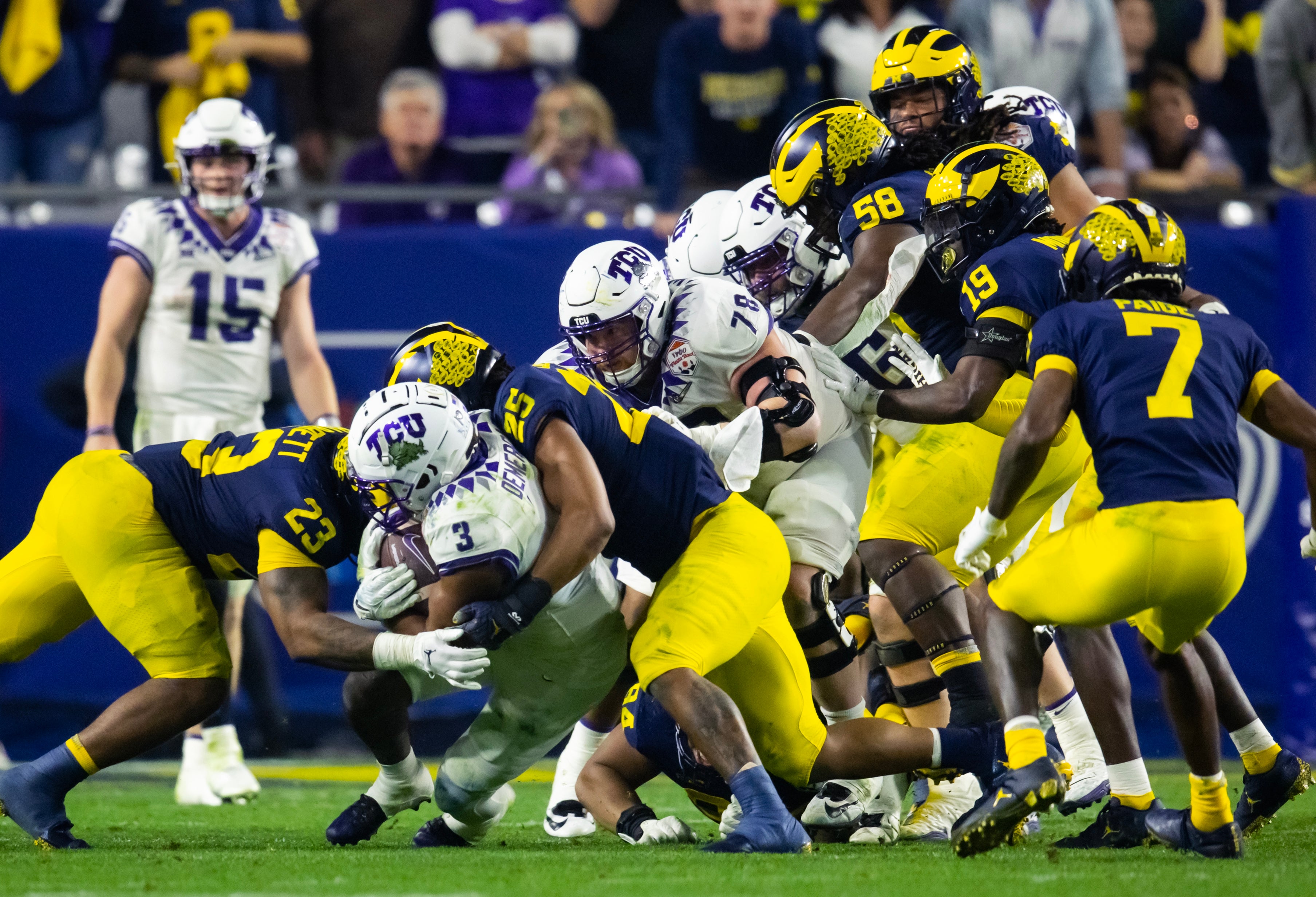 TCU Horned Frogs running back Emari Demercado (3) is tackled by Michigan Wolverines linebacker Junior Colson (25) during the 2022 Fiesta Bowl at State Farm Stadium.