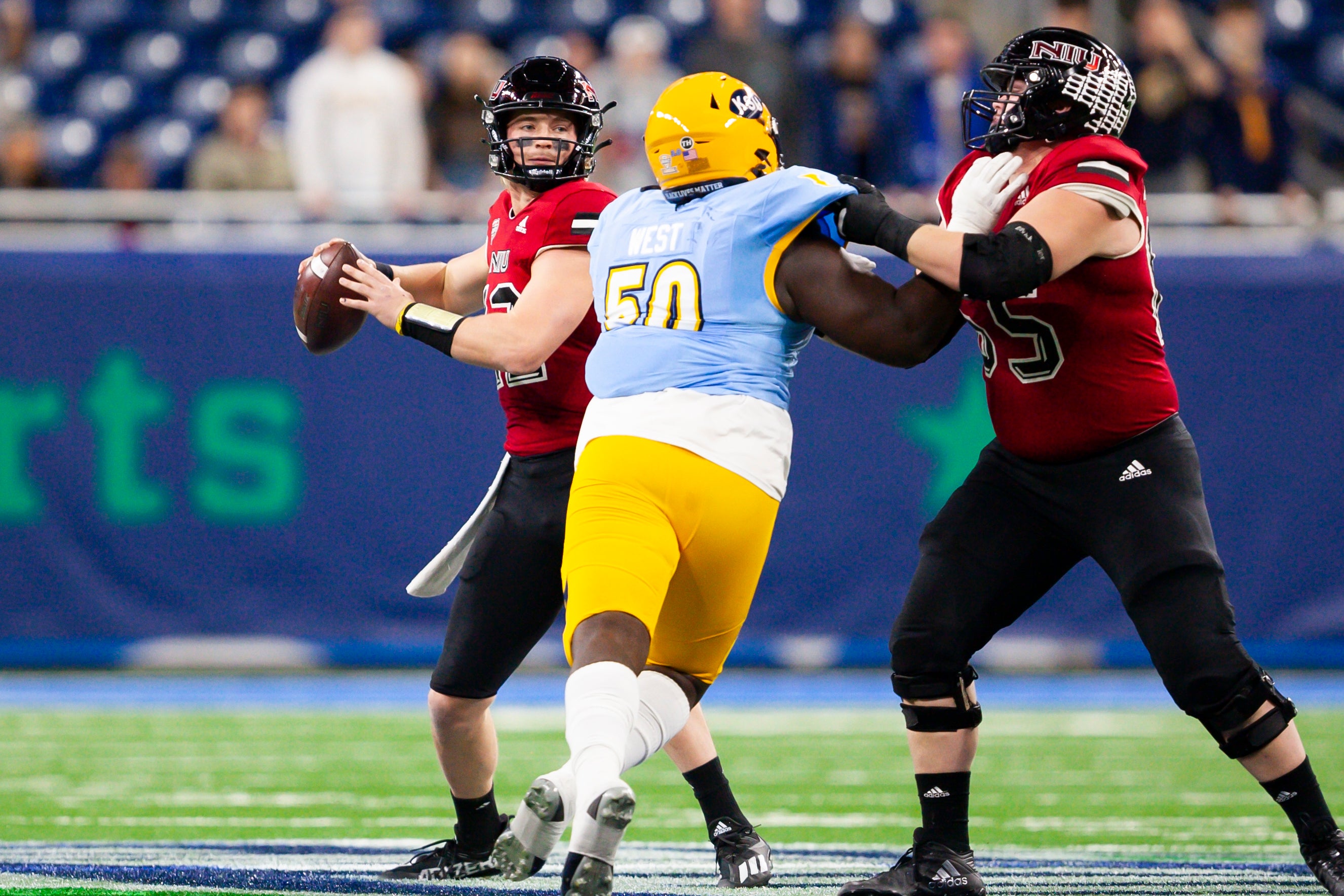 Dec 4, 2021; Detroit, MI, USA; Northern Illinois Huskies quarterback Rocky Lombardi (12) looks to pass the ball as he is pressured by Kent State Golden Flashes defensive lineman CJ West (50) during the first quarter of the MAC Championship Game at Ford Field.
