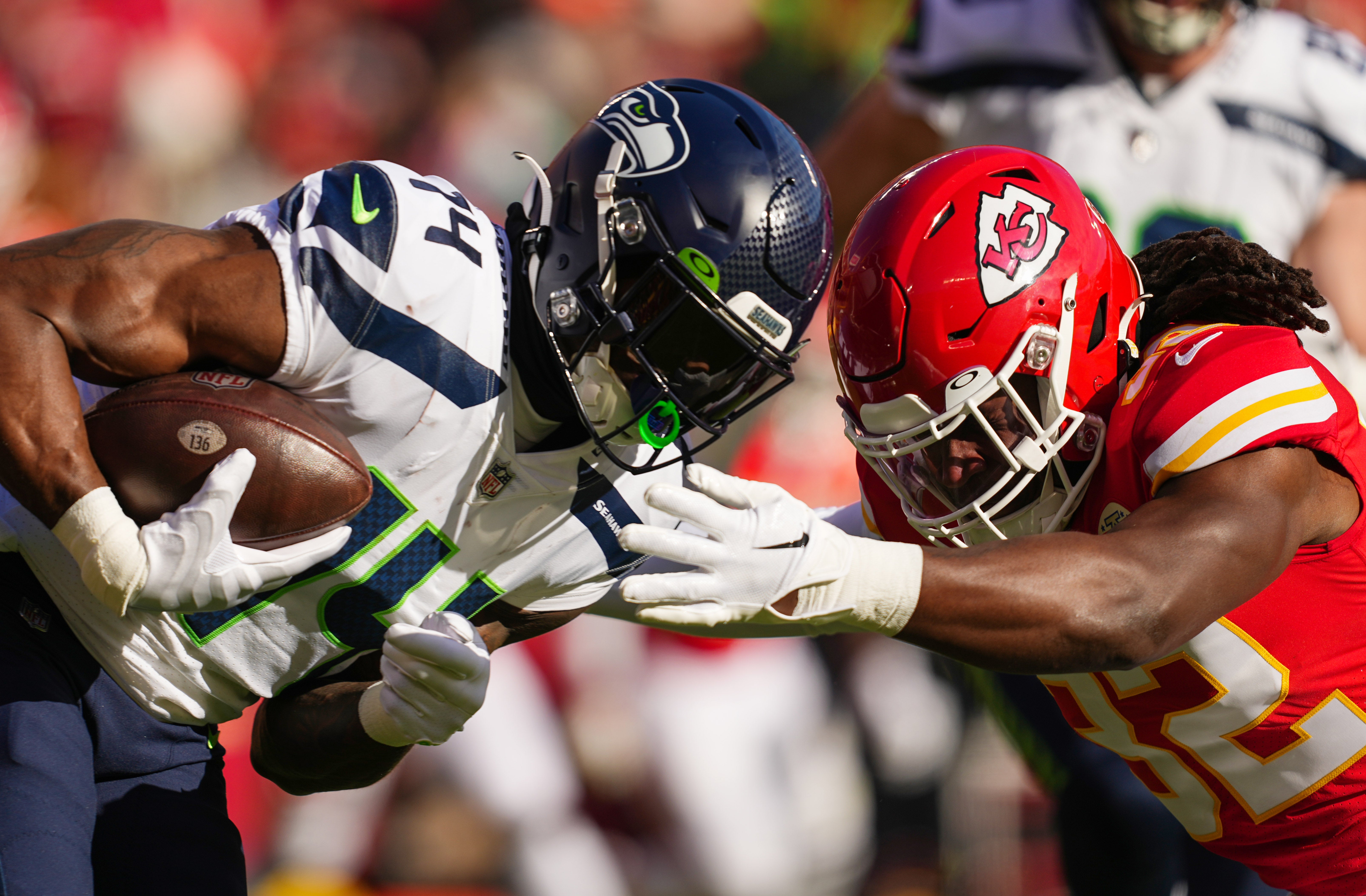 Dec 24, 2022; Kansas City, Missouri, USA; Seattle Seahawks wide receiver DK Metcalf (14) runs with the ball against Kansas City Chiefs linebacker Nick Bolton (32) during the first half at GEHA Field at Arrowhead Stadium.
