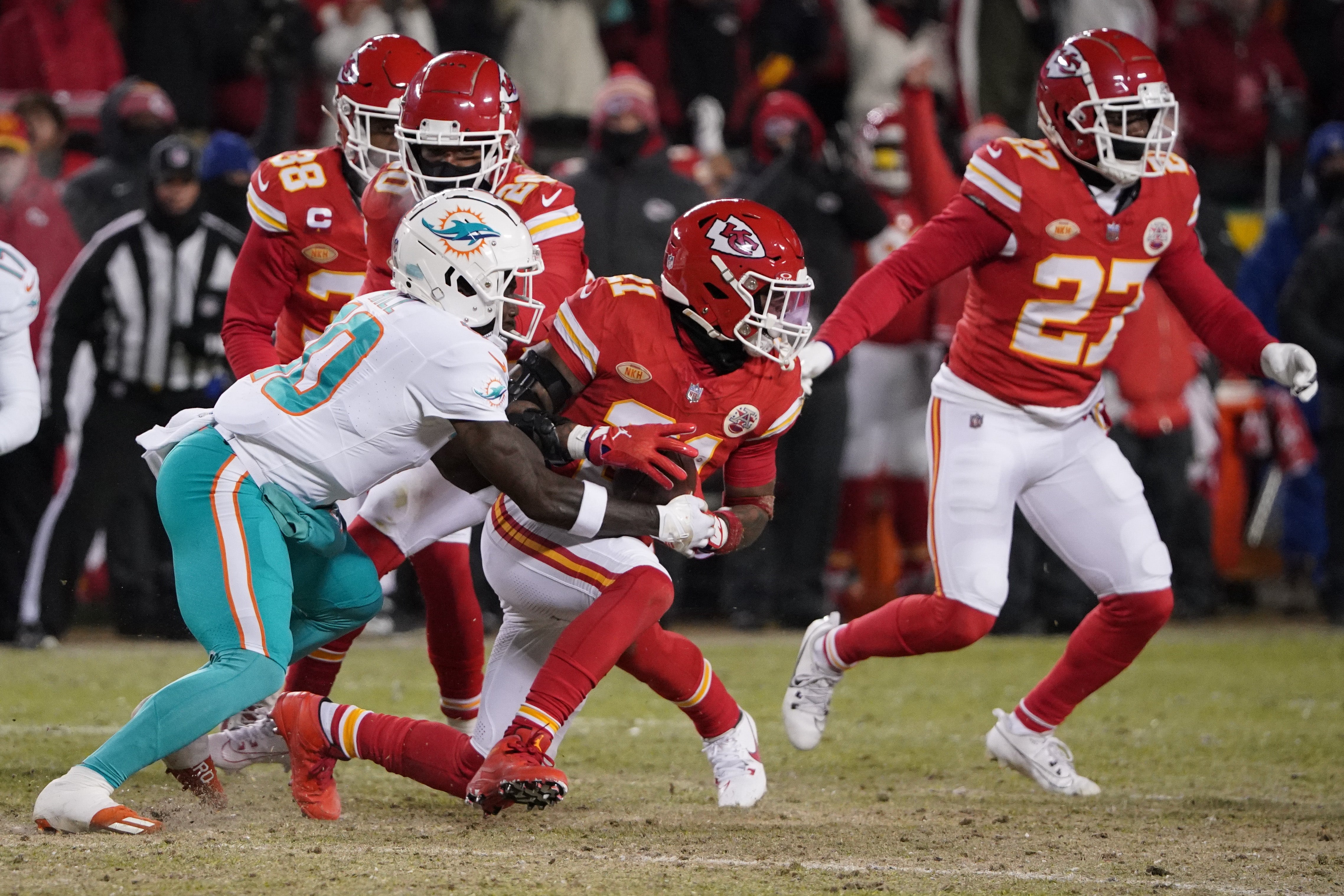 Jan 13, 2024; Kansas City, Missouri, USA; Kansas City Chiefs safety Mike Edwards (21) runs the ball after intercepting a pass intended for Miami Dolphins wide receiver Tyreek Hill (10) during the first half of the 2024 AFC wild card game at GEHA Field at Arrowhead Stadium.
