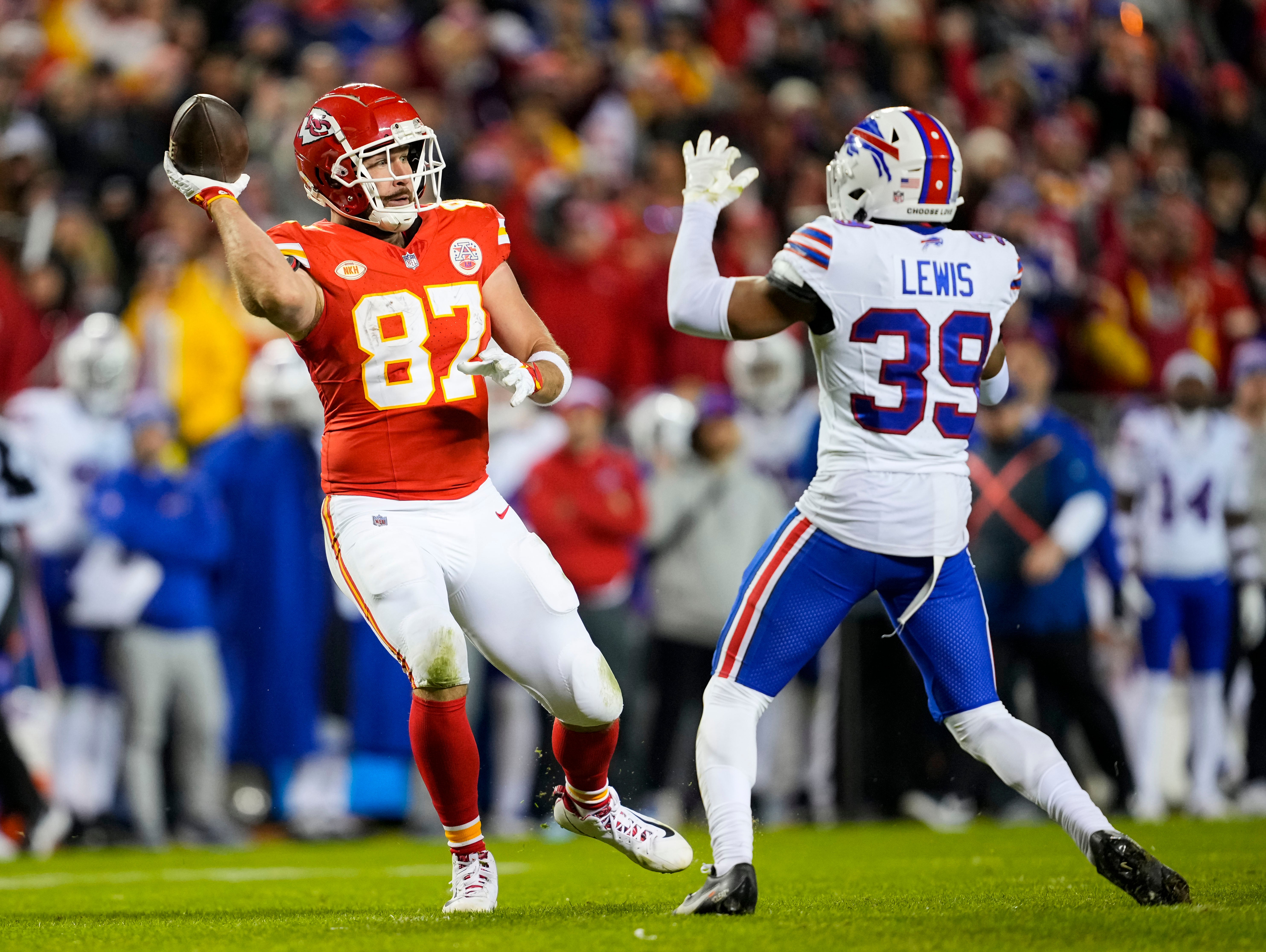 Dec 10, 2023; Kansas City, Missouri, USA; Kansas City Chiefs tight end Travis Kelce (87) laterals the ball against Buffalo Bills cornerback Cam Lewis (39) during the second half at GEHA Field at Arrowhead Stadium.