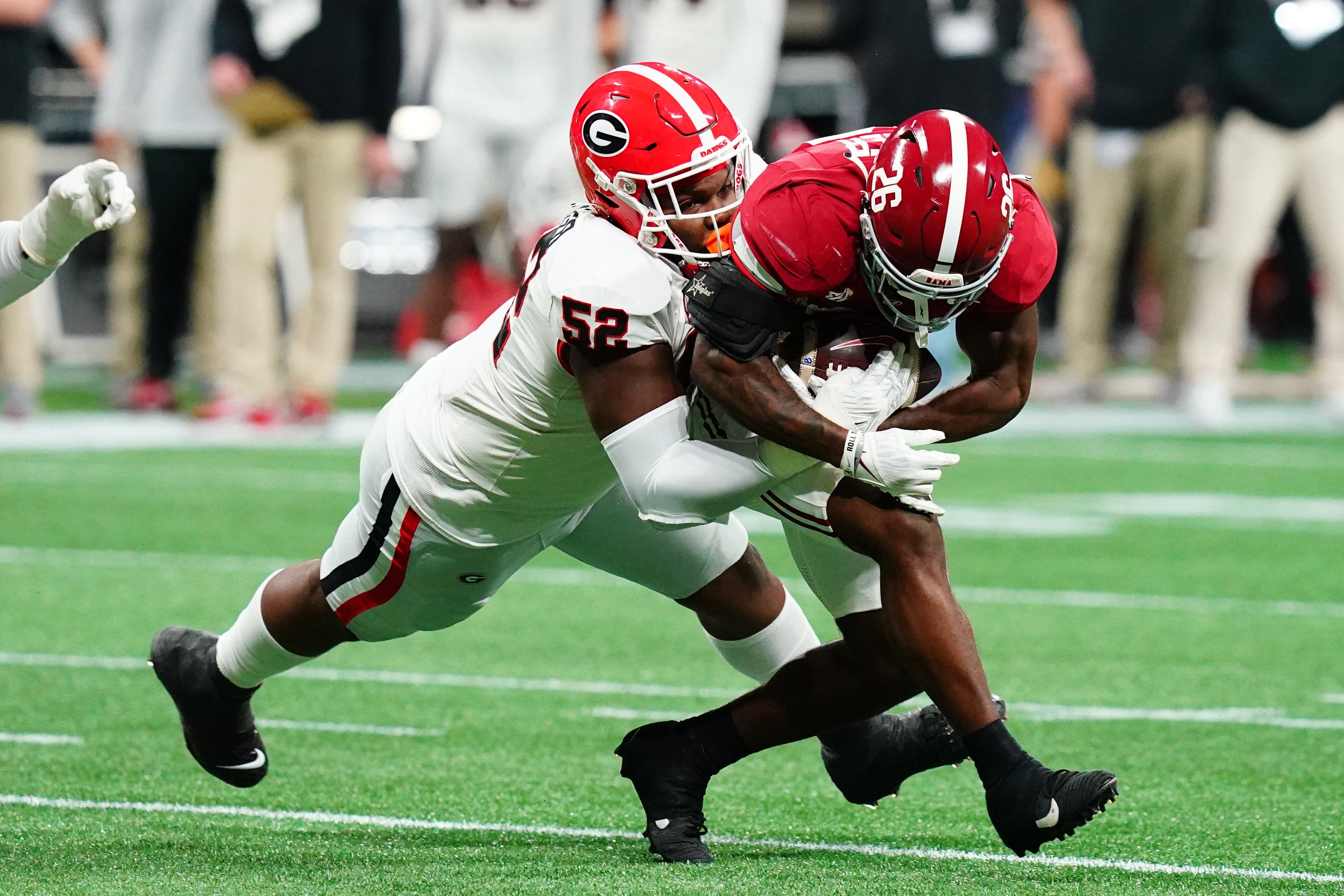 Georgia Bulldogs defensive lineman Christen Miller (52) tackles Alabama Crimson Tide running back Jam Miller (26) in the first quarter of the SEC Championship at Mercedes-Benz Stadium.