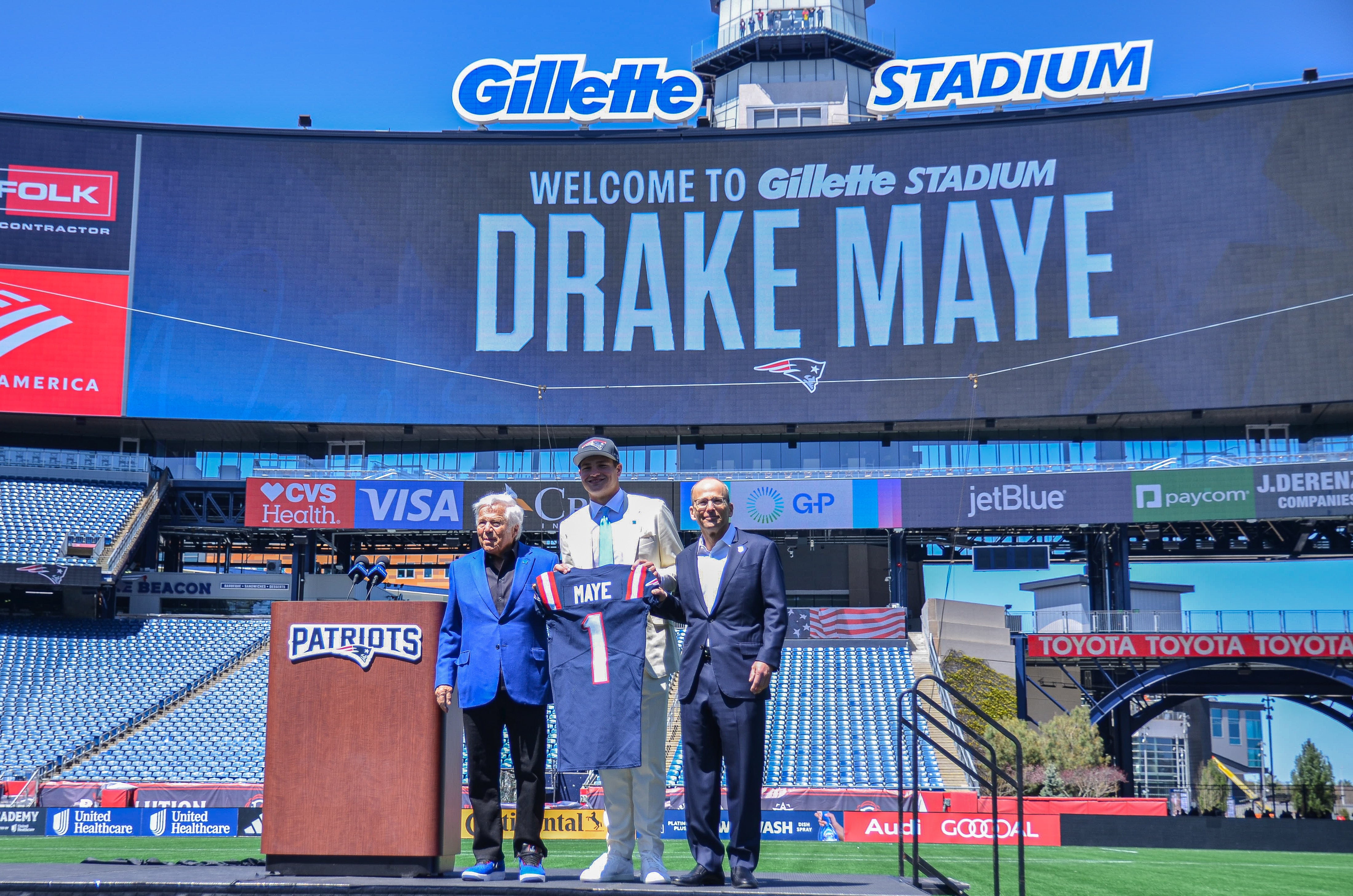 Drake Maye poses with a Patriots jersey at Gillette Stadium on Friday, April 26, after being selected by New England in the first round of the 2024 NFL Draft.