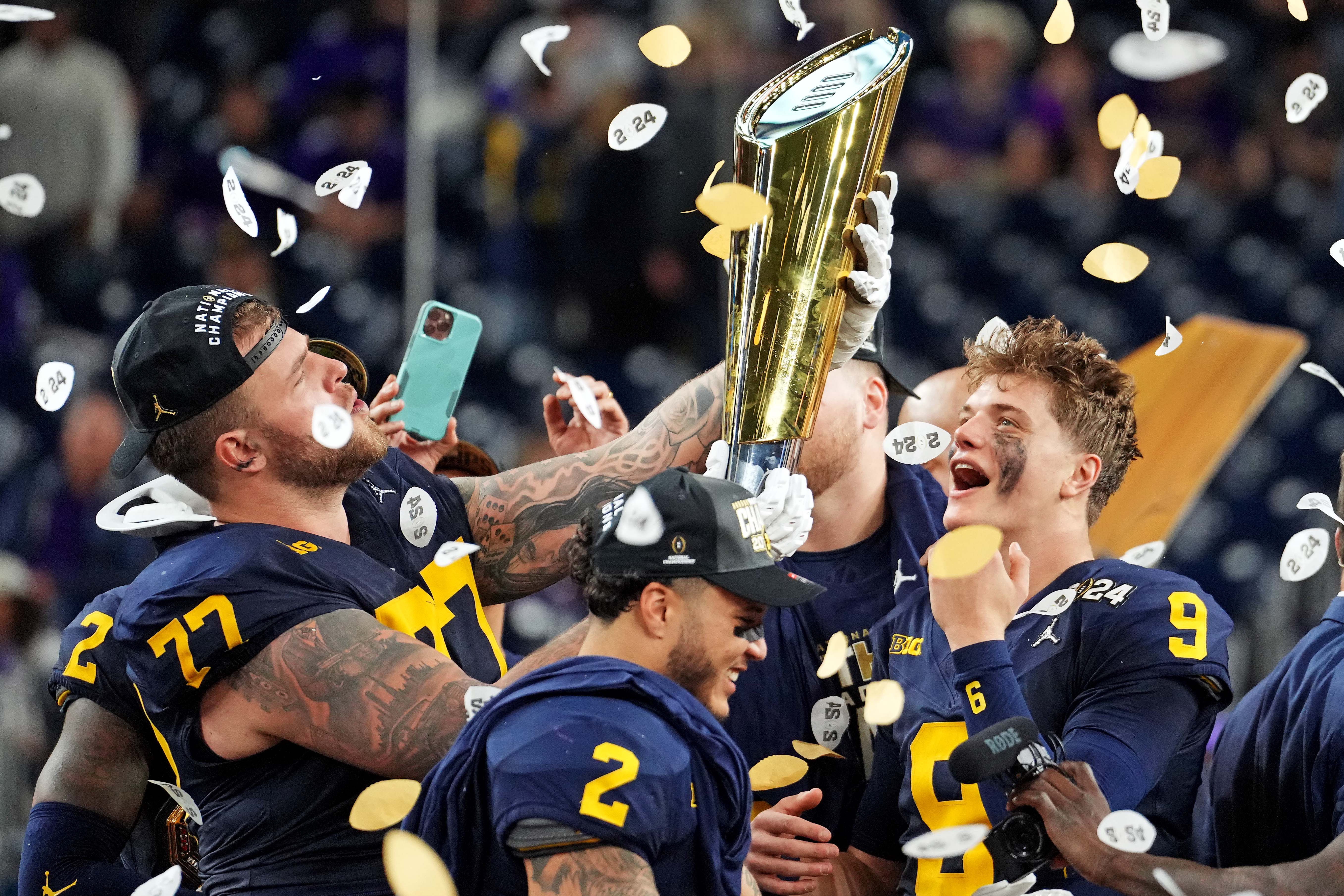Jan 8, 2024; Houston, TX, USA; Michigan Wolverines offensive lineman Trevor Keegan (77) and quarterback J.J. McCarthy (9) celebrate with CFP National Championship trophy after the Washington Huskies in the 2024 College Football Playoff national championship game at NRG Stadium.