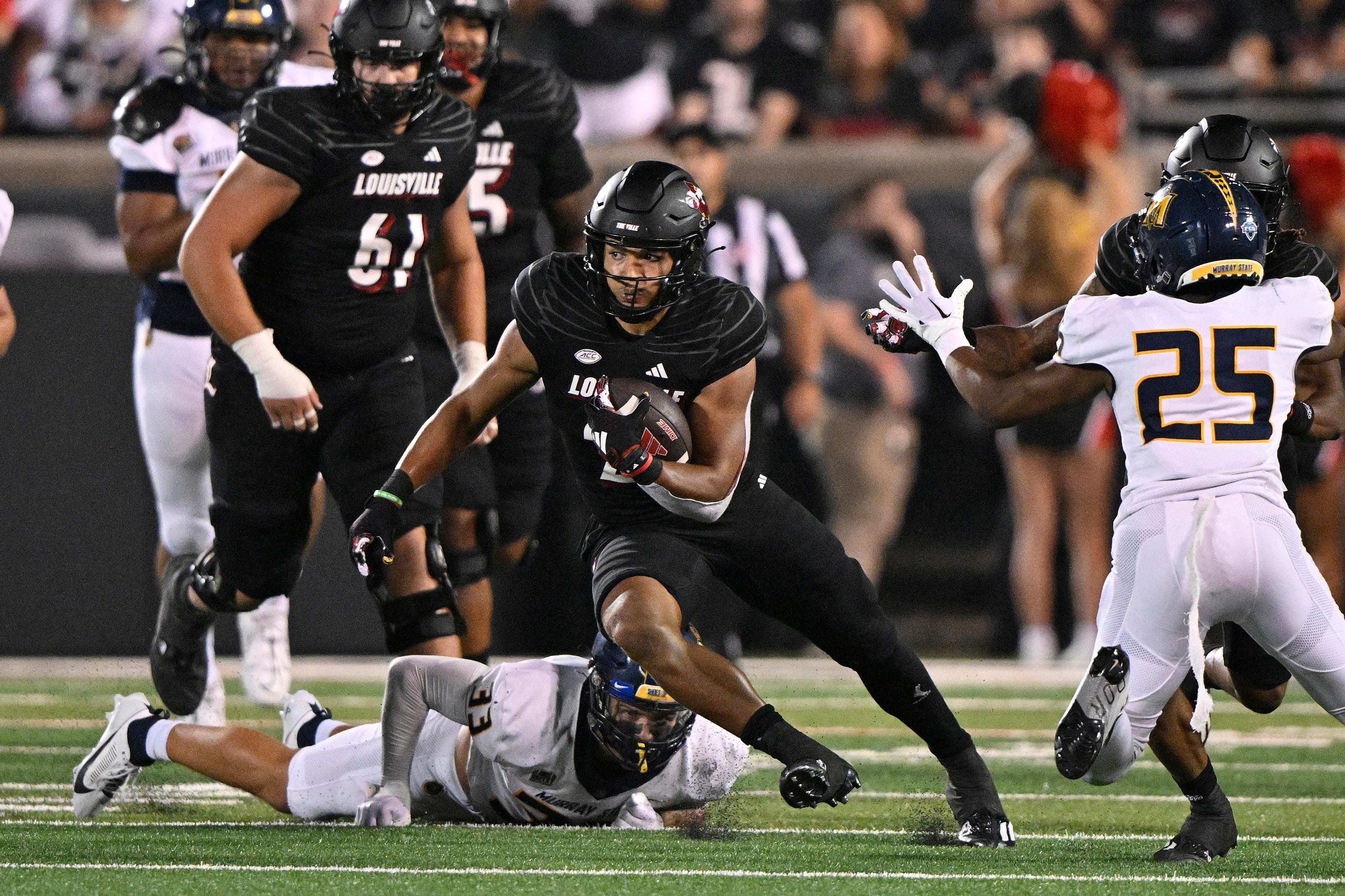 Sep 7, 2023; Louisville, Kentucky, USA; Louisville Cardinals running back Isaac Guerendo (23) runs the ball against Murray State Racers linebacker Nick Walker (33) during the second quarter at L&N Federal Credit Union Stadium.
