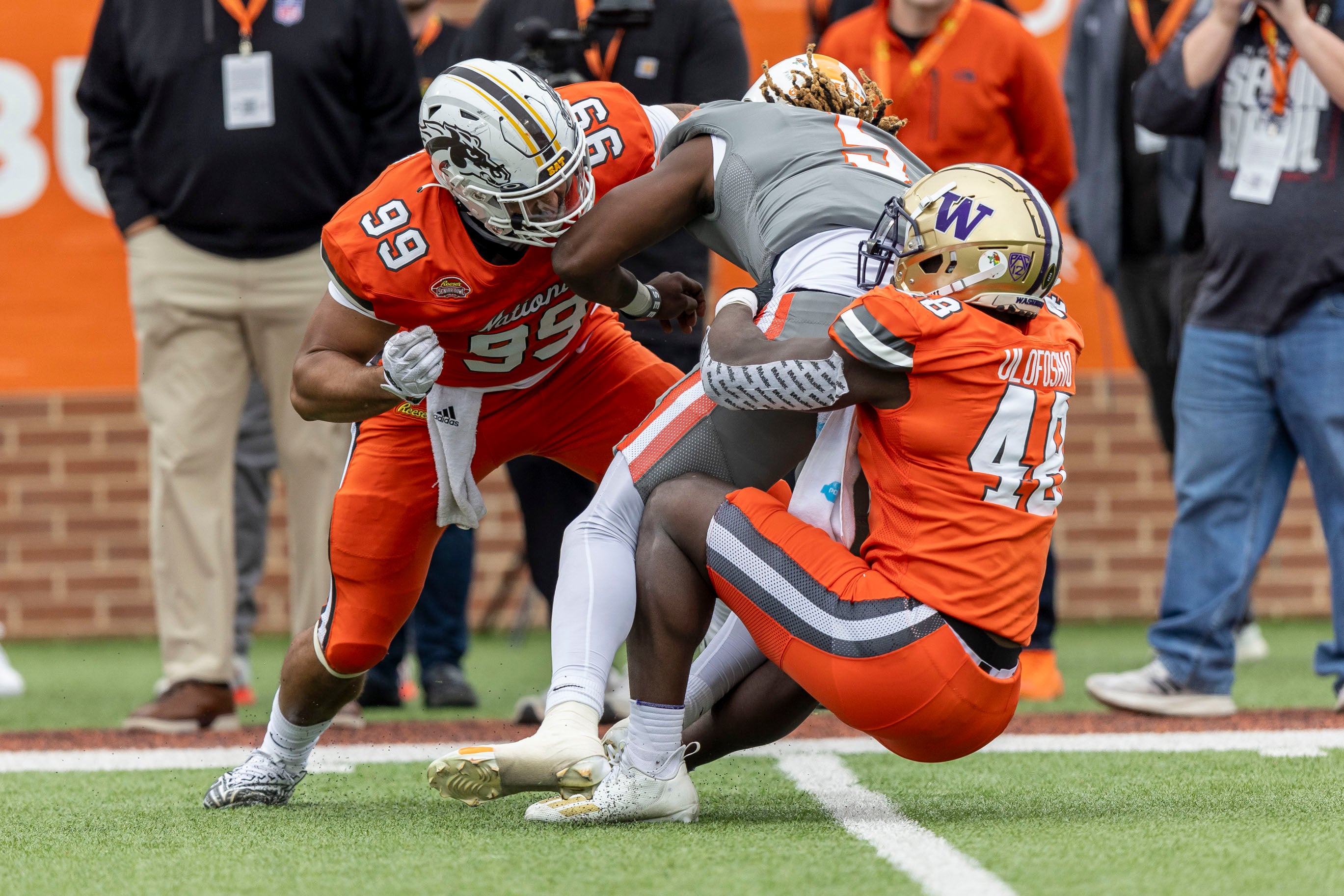 National edge Marshawn Kneeland of Western Michigan (99) and National linebacker Edefuan Ulofoshio of Washington (48) sack American quarterback Joe Milton III of Tennessee (5) during the first half of the 2024 Senior Bowl football game at Hancock Whitney Stadium.