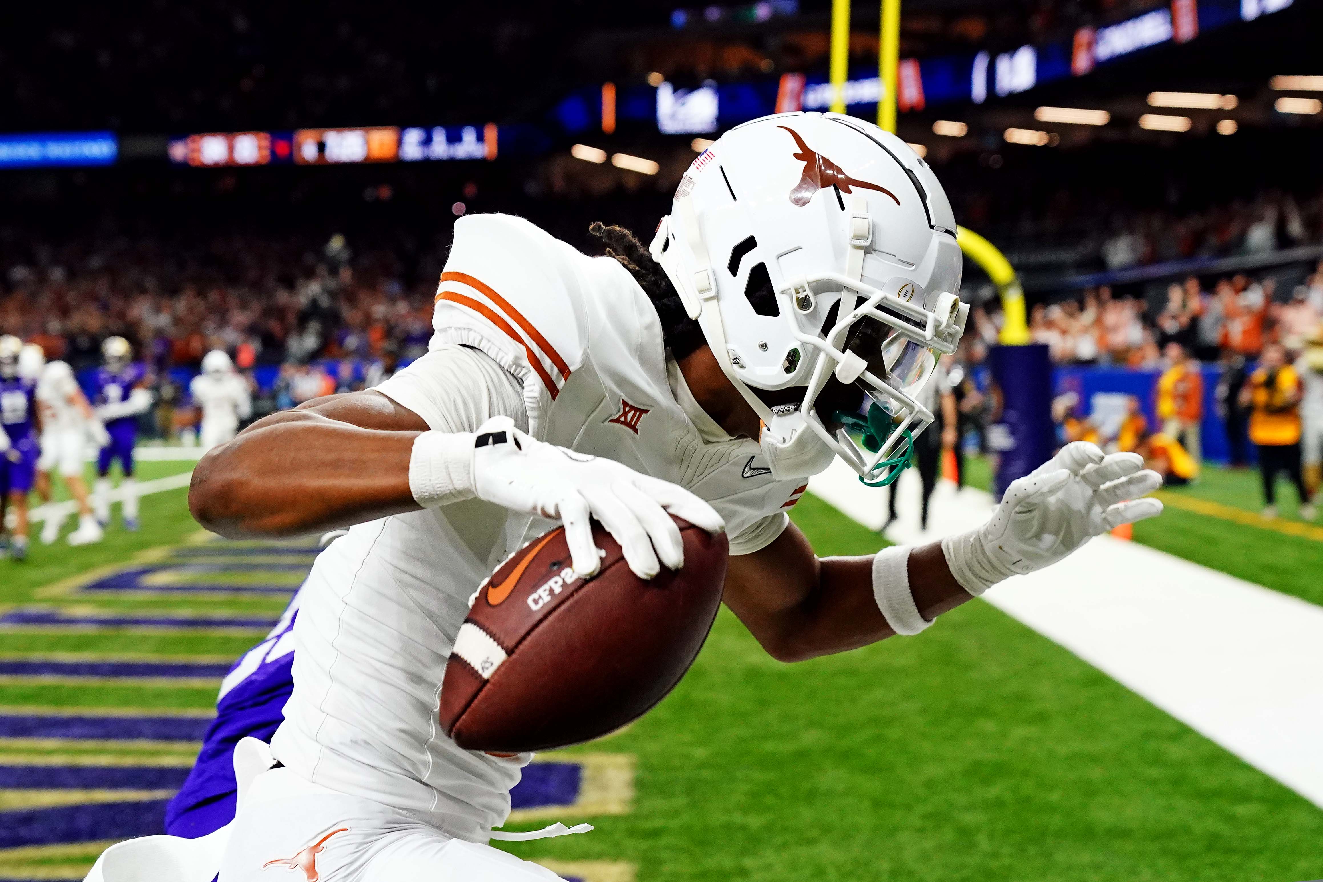 Jan 1, 2024; New Orleans, LA, USA; Texas Longhorns wide receiver Adonai Mitchell (5) catches a touchdown pass against Washington Huskies running back Ryder Bumgarner (25) during the fourth quarter in the 2024 Sugar Bowl college football playoff semifinal game at Caesars Superdome.