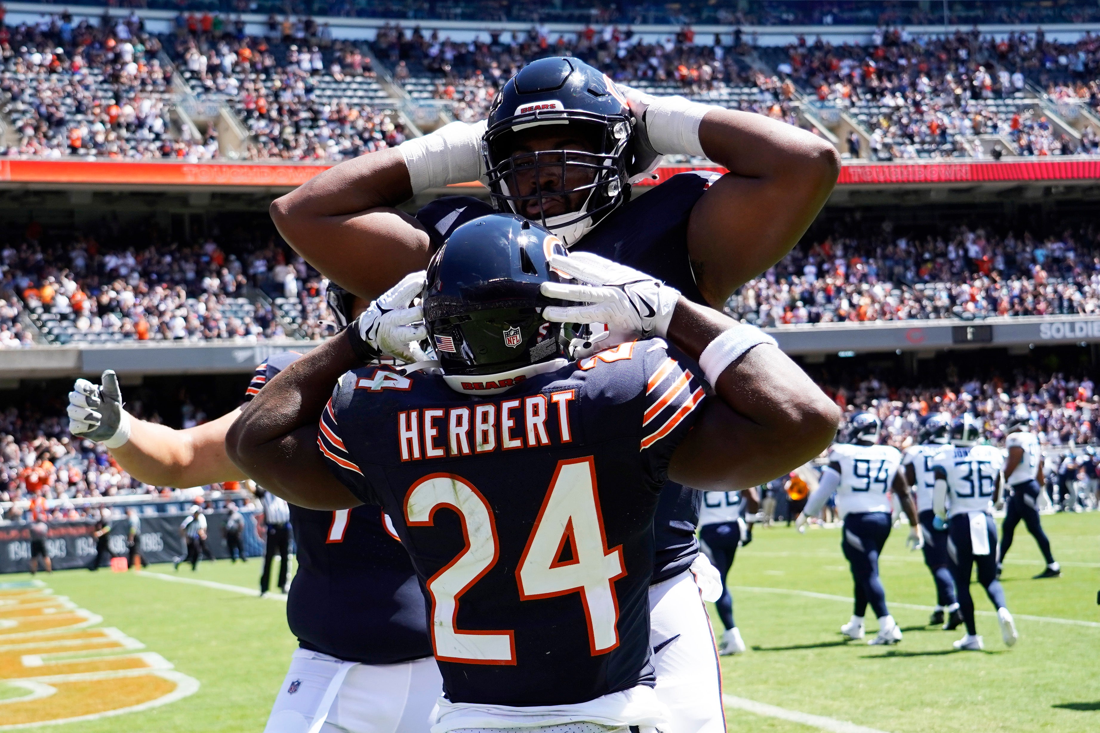Aug 12, 2023; Chicago, Illinois, USA; Chicago Bears running back Khalil Herbert (24) celebrates his touchdown against the Tennessee Titans with offensive tackle Braxton Jones (70) at Soldier Field.